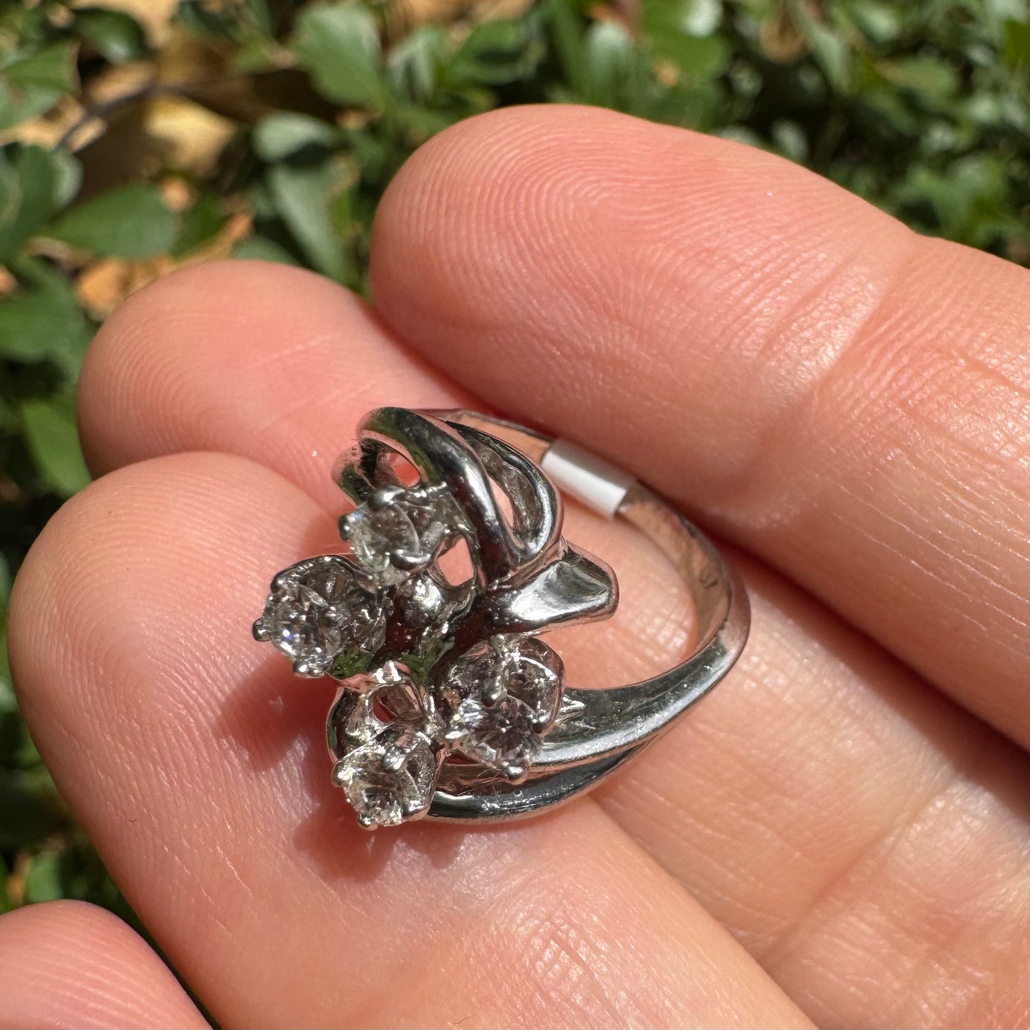 14K gold ring set with four brilliant-cut Diamonds, arranged in an elegant flowing design