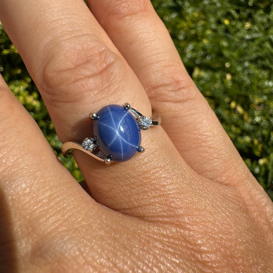 טבעת זהב לבן 14 קראט משובצת אבן ספיר "כוכב" ויהלומים משני הצדדים.