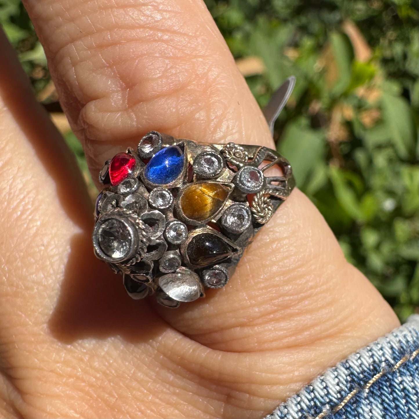 14K gold ring set with a central transparent gemstone surrounded by a vibrant mosaic of colorful gemstones -set in an ornate, handcrafted design