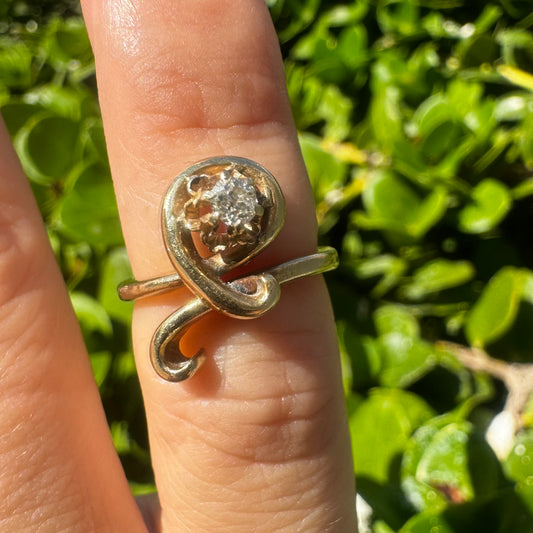 14K gold ring set with a brilliant-cut Diamond, embraced by a flowing, sculptural gold design