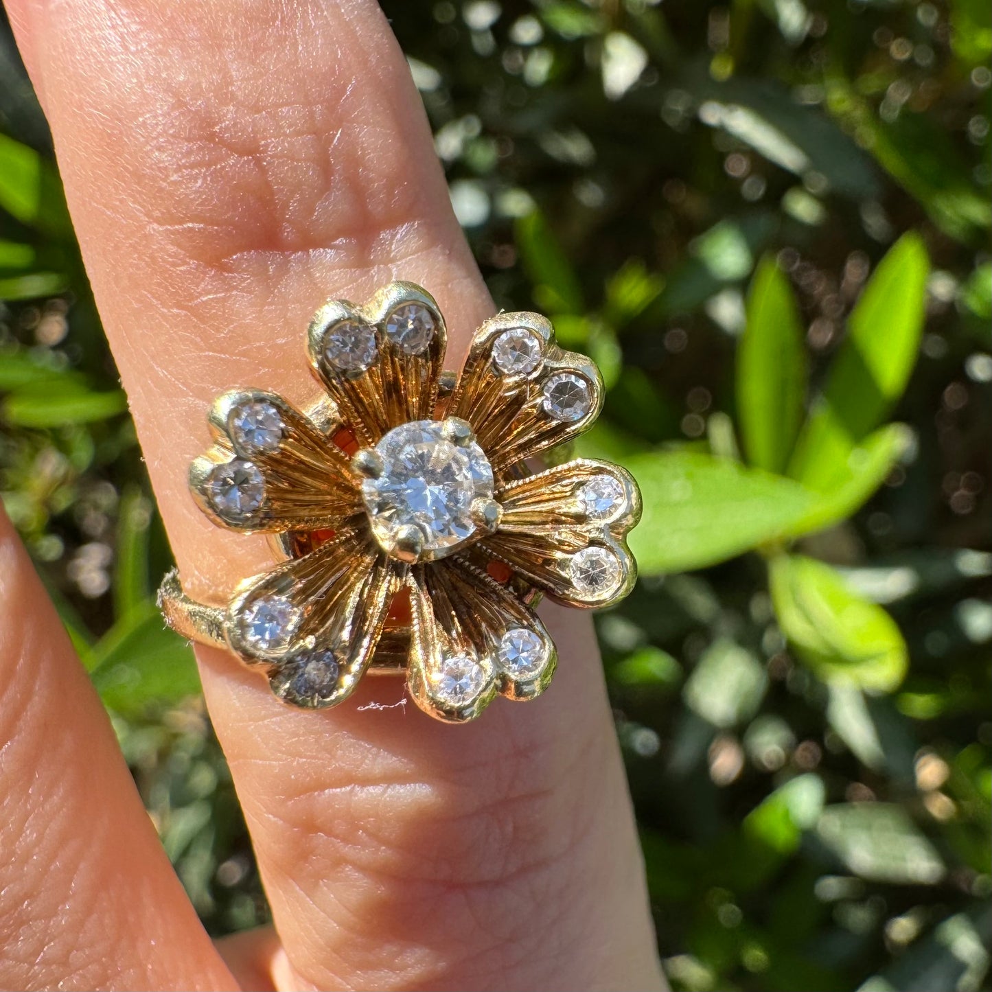 טבעת זהב צהוב 14 קראט בצורת פרח משובצת יהלום במרכז וסביבו משובצים יהלומים בתוך עלי הכותרת