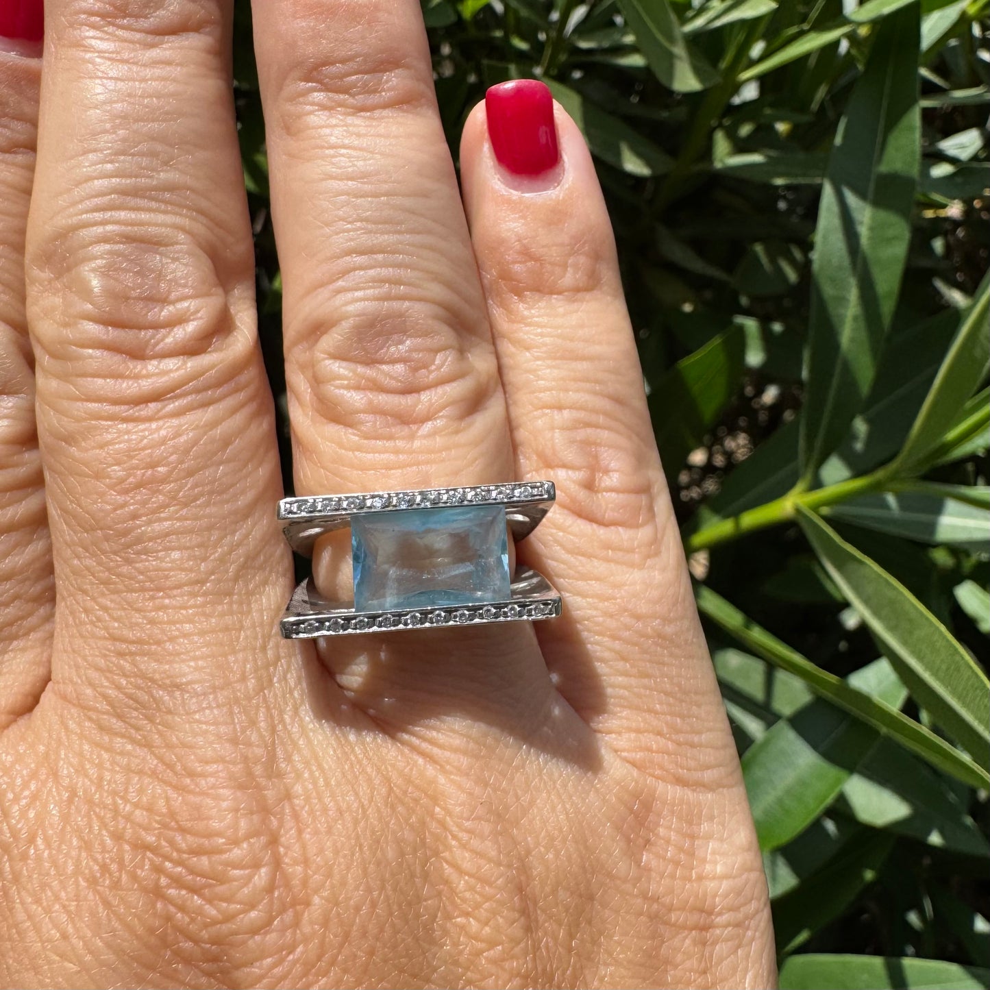 18K gold ring set with a stunning Aquamarine centerpiece held between two sleek gold bars set with delicate Diamonds.