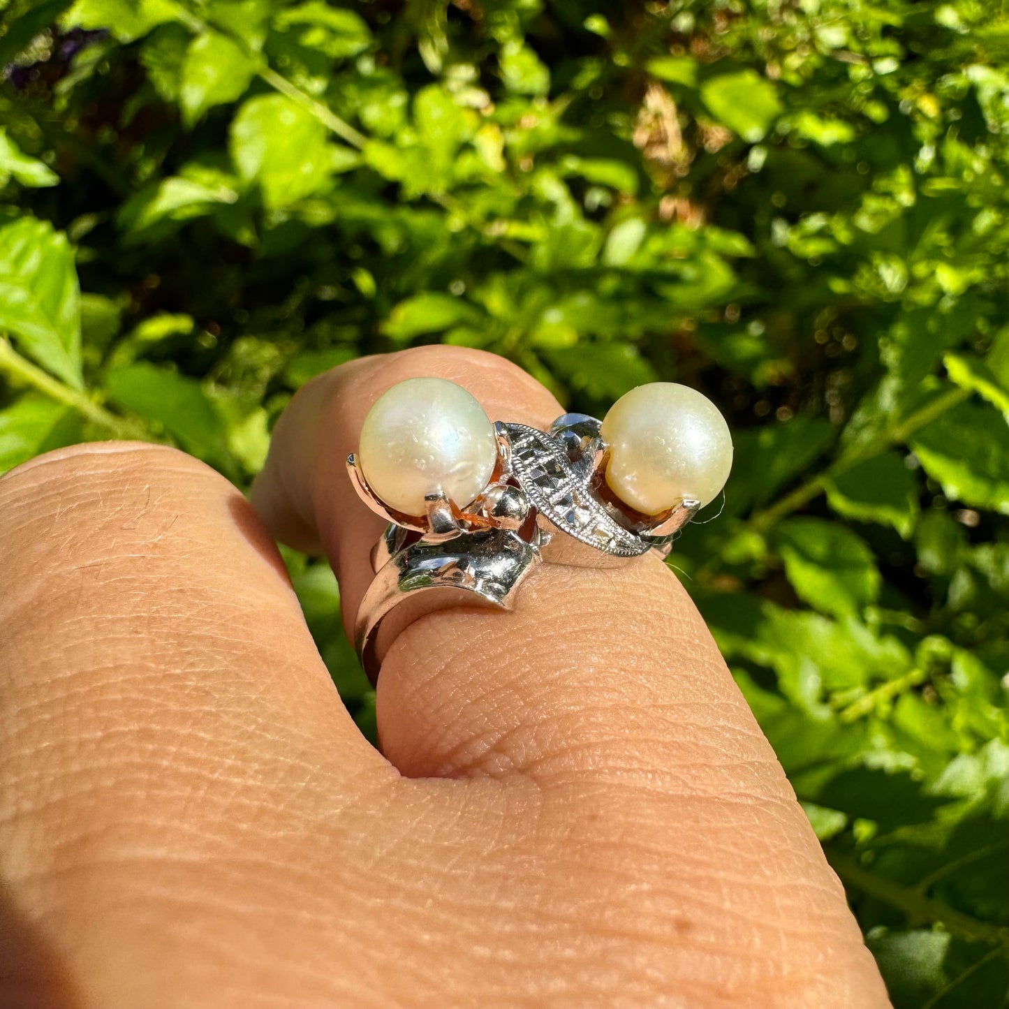 14K gold ring featuring two round white pearls set side by side, accented with a small decorative detail between them & Diamonds