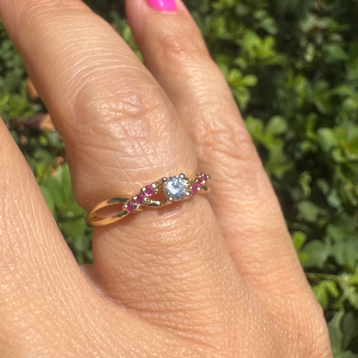 14K gold ring set with a central round Diamond, accented with Rubies along the band.