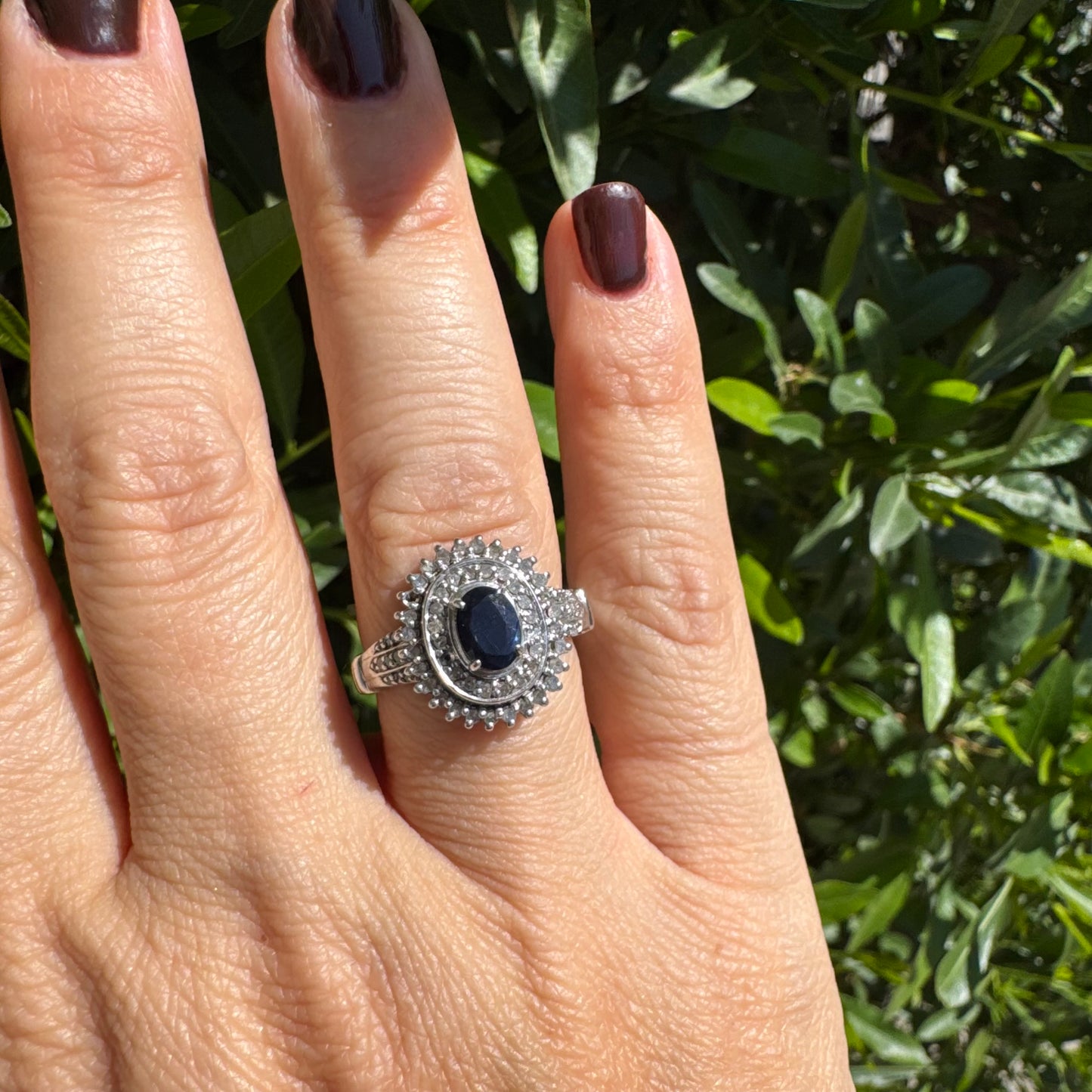 14K gold ring set with an oval-cut Sapphire, surrounded by a stunning double halo of brilliant round Diamonds