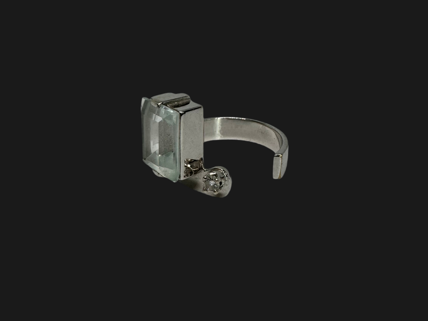 18K gold ring set with a rectangular step-cut Aquamarine set in a sculptural white gold band & a sparkling Diamond