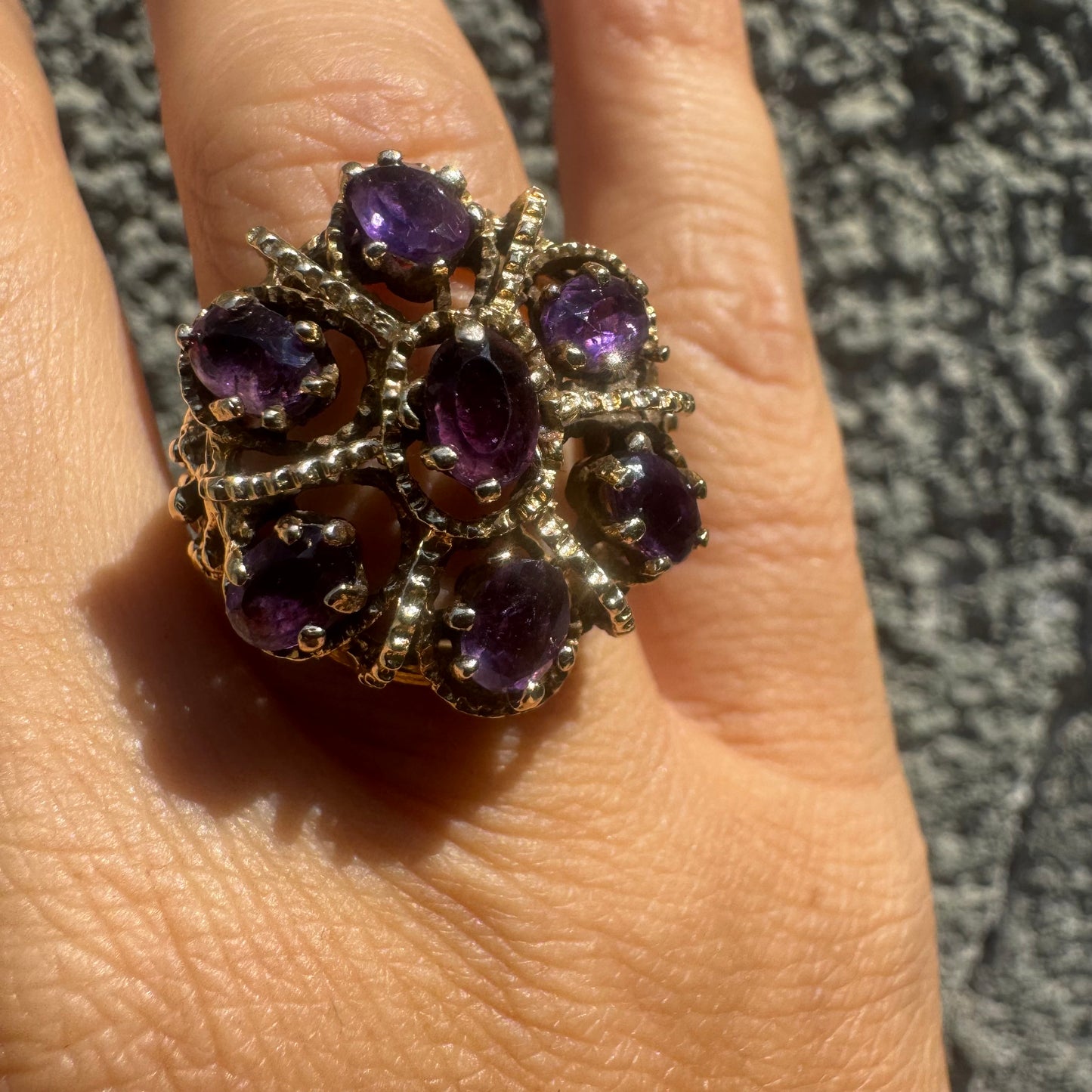 14K gold ring set with deep purple amethysts in an ornate floral design.