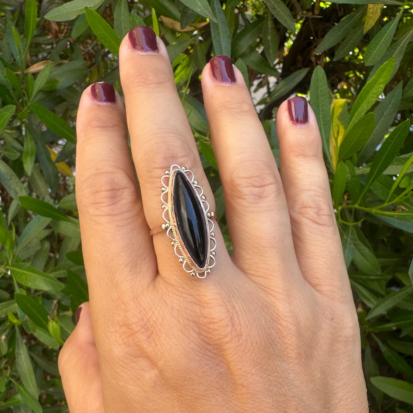 14K gold ring featuring a long marquise-shaped black Onyx stone, framed with delicate decorative details around the setting.
