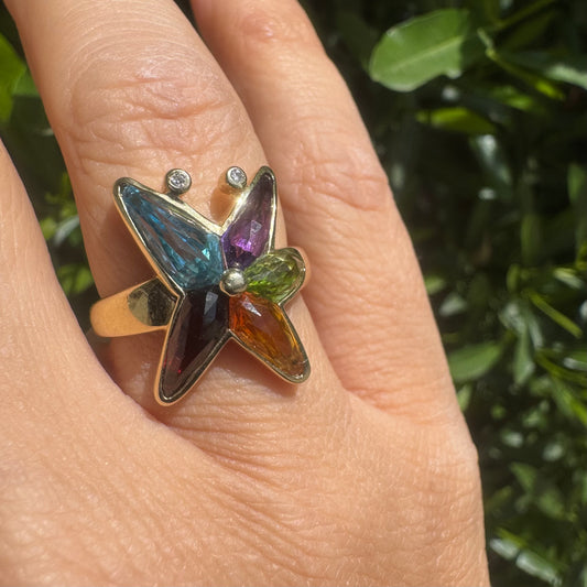 טבעת זהב צהוב 14 קראט, בעיצוב פרפר צבעוני וקסום, משובצת אבני חן במגוון גוונים – טורמלין, סיטרין, פרידוט, אמטיסט.