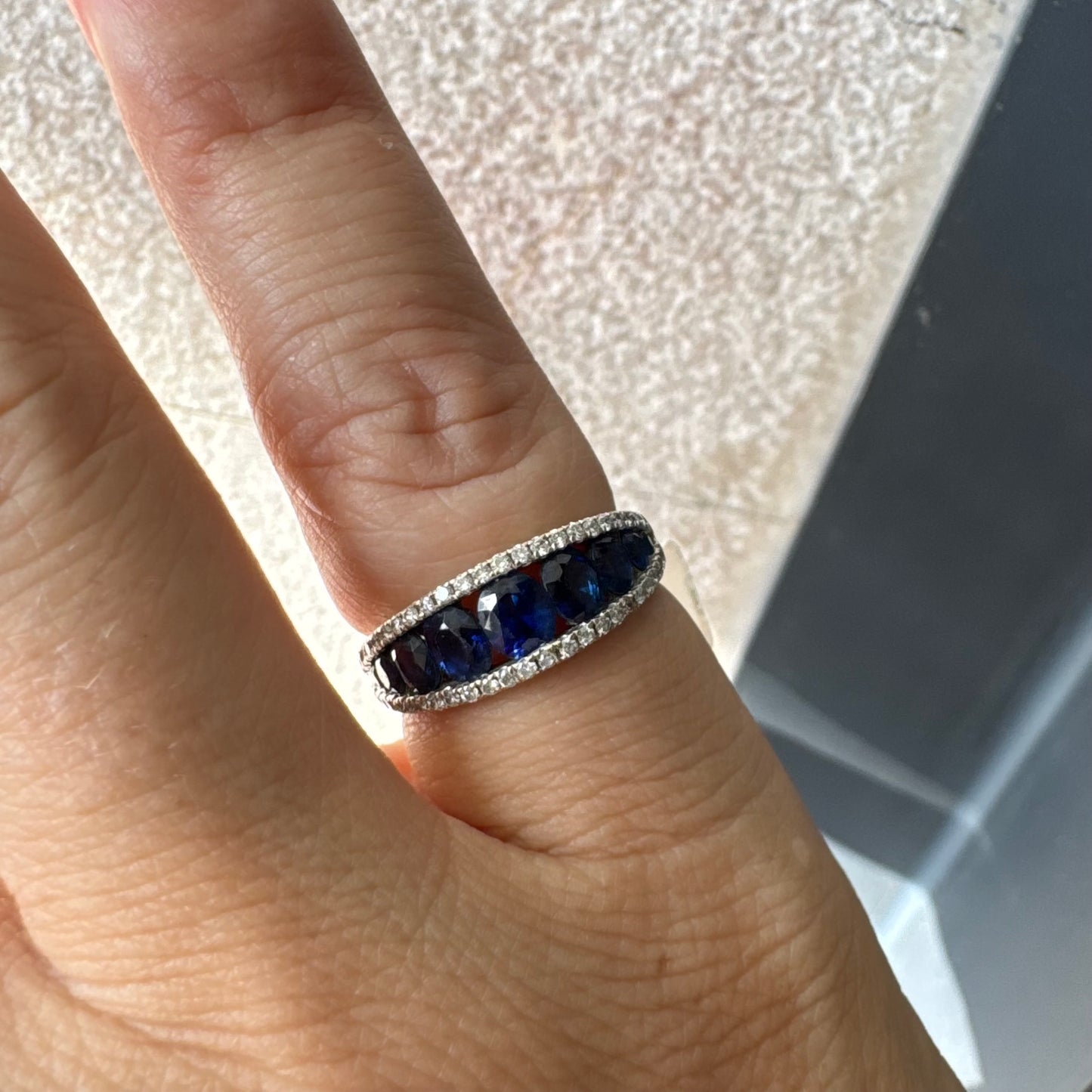 טבעת זהב צהוב 18 קראט משובצת שורת אבני ספיר כחולות בליטוש אובלי, משובצות במרכז ומוקפות בשתי שורות של יהלומים אחת מעל ואחת מתחת.