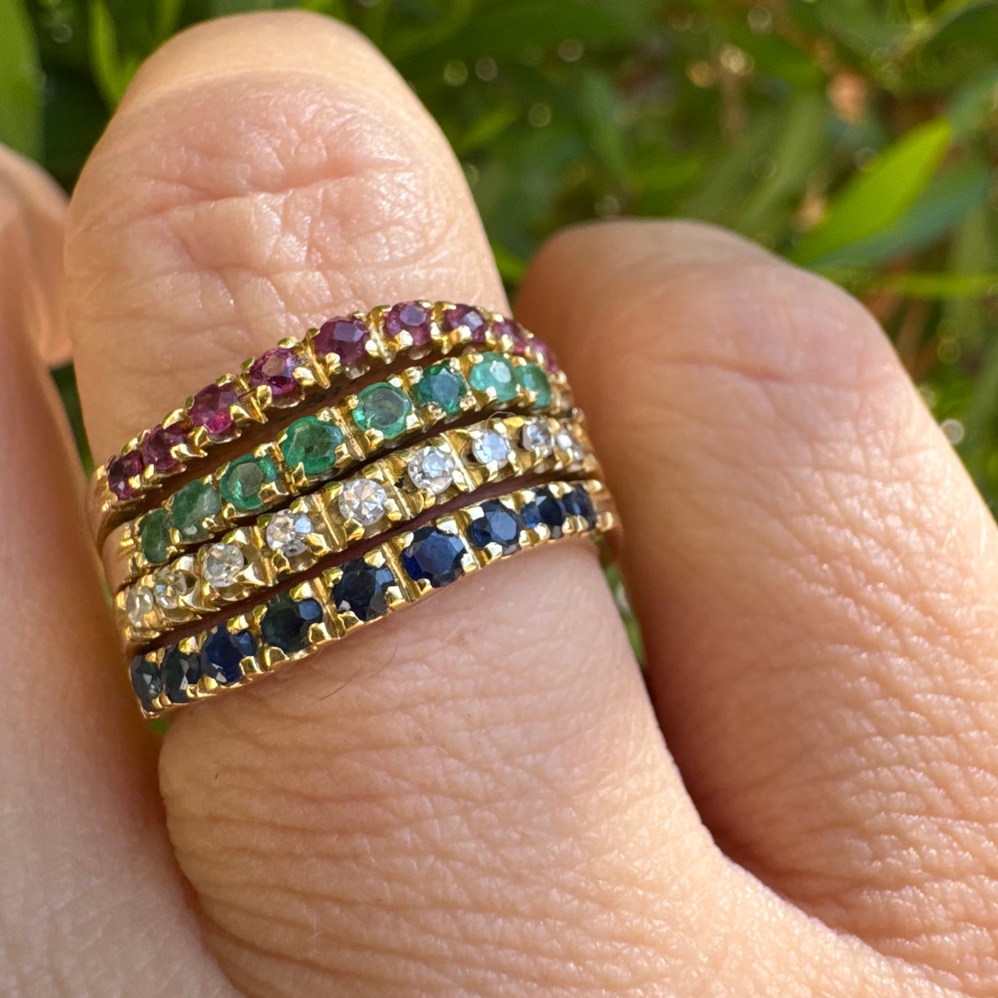 18K yellow gold ring set with vibrant rows of Sapphires, Emeralds, Rubies, and Diamonds