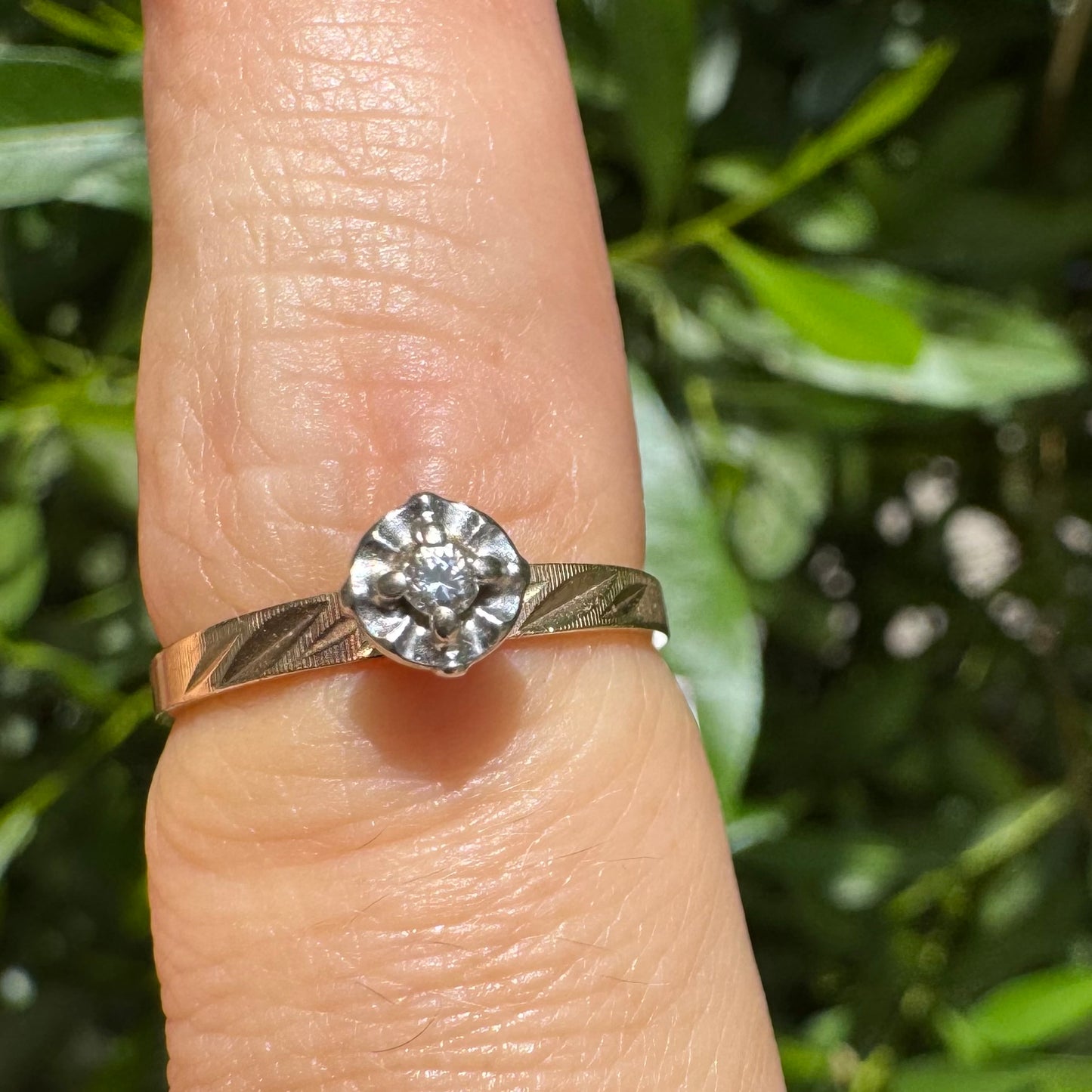 14K gold ring with a delicate floral-style setting, set with a small central Diamond.