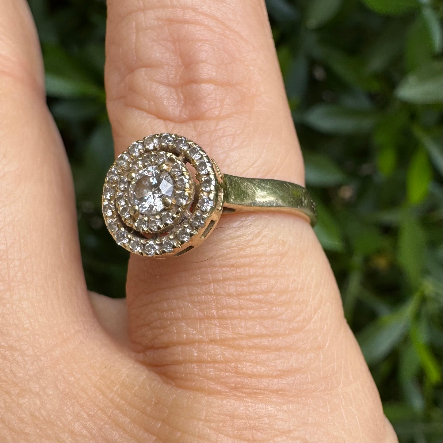 14K gold ring with a round center Diamond, surrounded by two rows of small sparkling Diamonds.