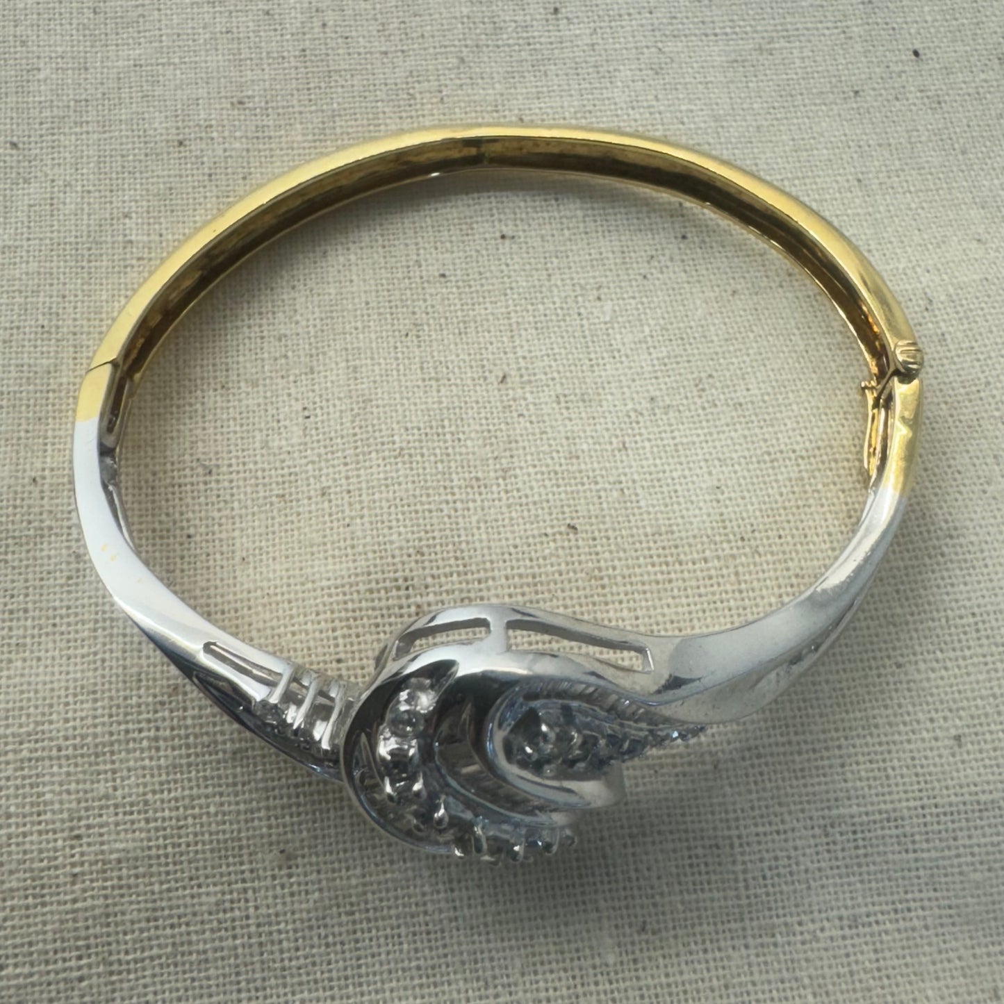 צמיד מרהיב מזהב לבן 14 קראט, בעיצוב גלים דינמי המשובץ בשיבוץ מרוכב של יהלומים עגולים ובחיתוך באגט.