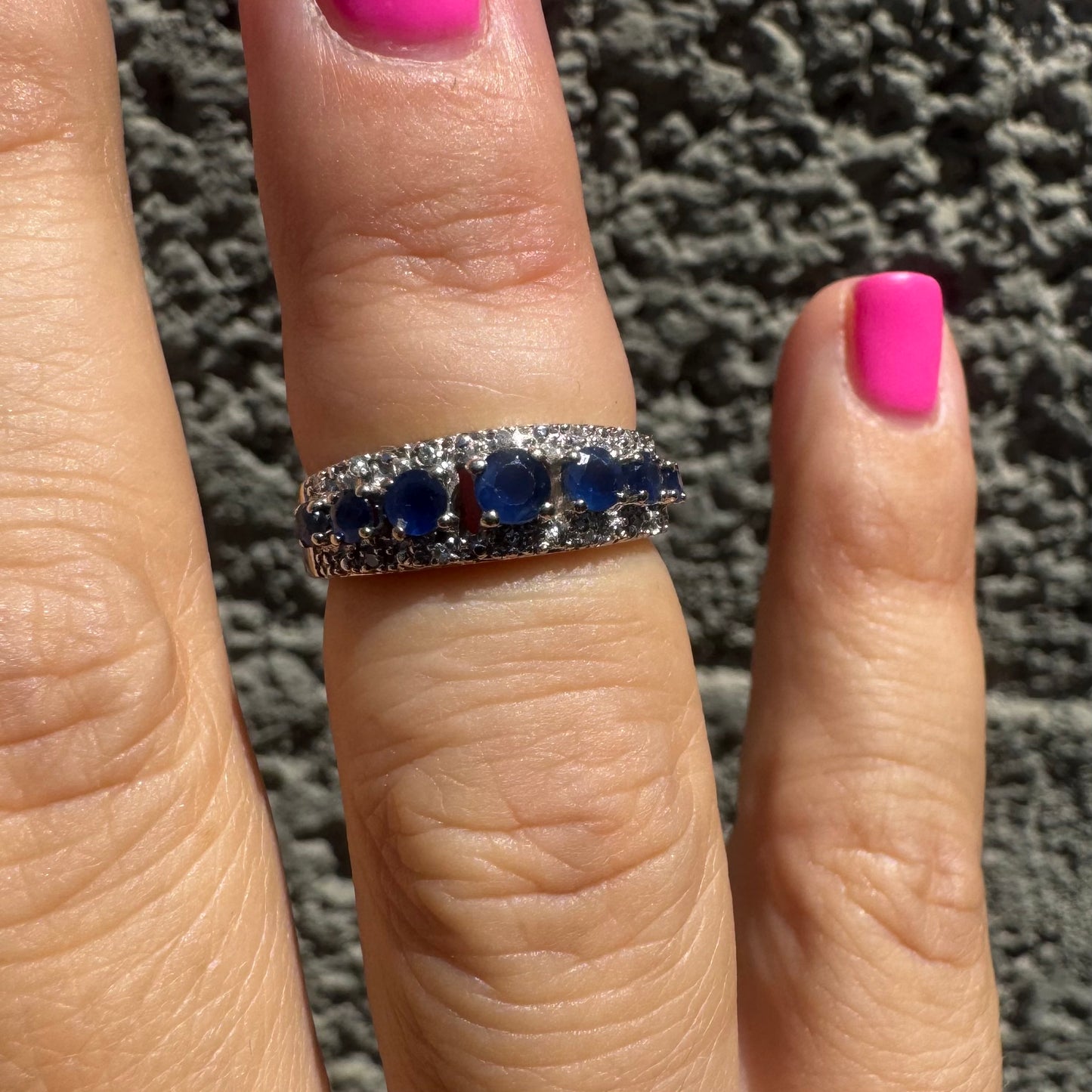 18K gold ring set with deep blue sapphires in a classic round cut, framed by two shimmering rows of brilliant Diamonds.