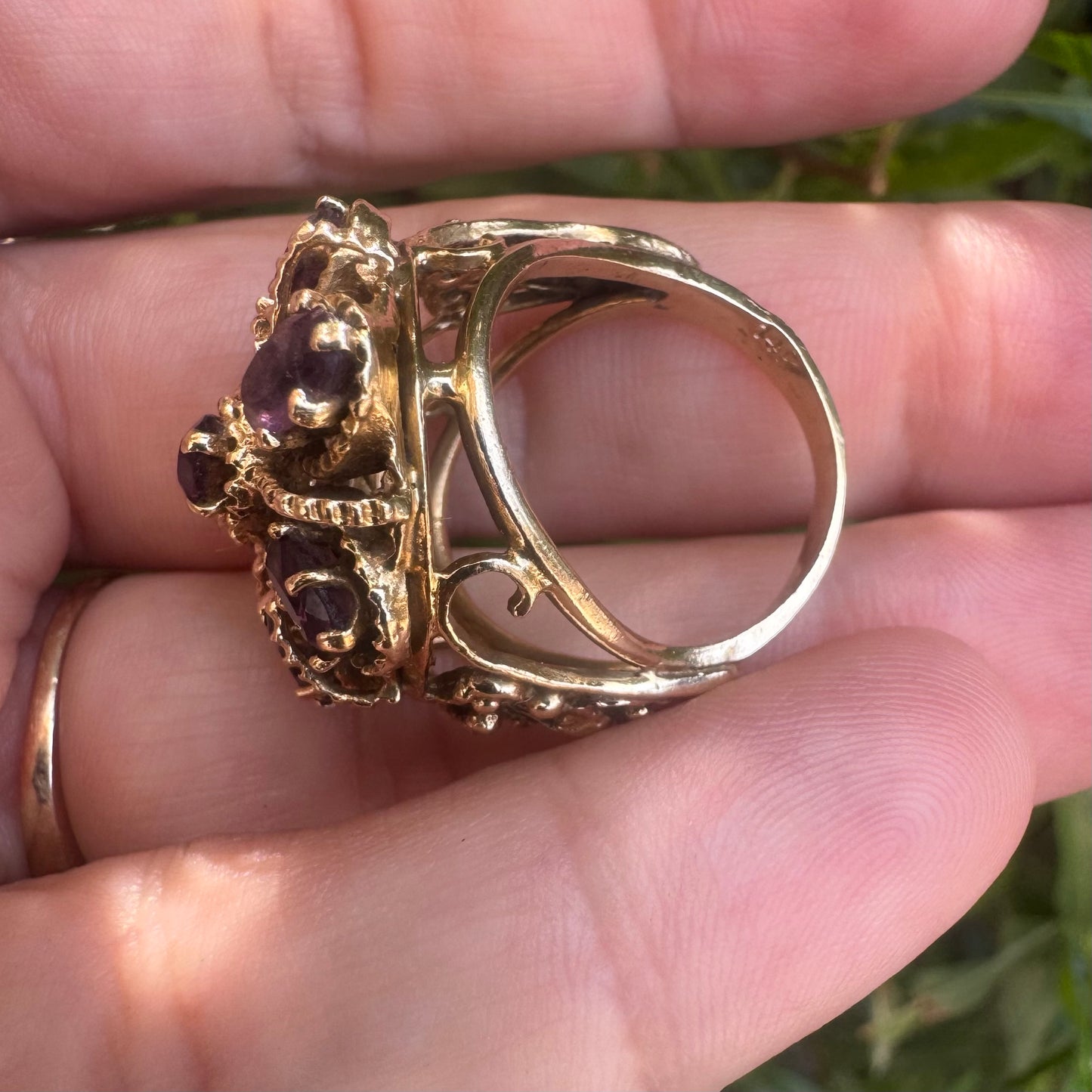 14K gold ring set with deep purple amethysts in an ornate floral design.