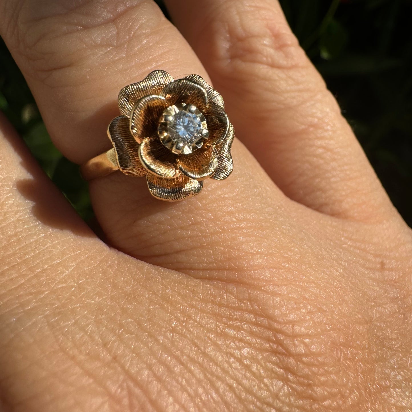 14K Gold floral ring set with delicately textured petals and a sparkling Diamond at the center