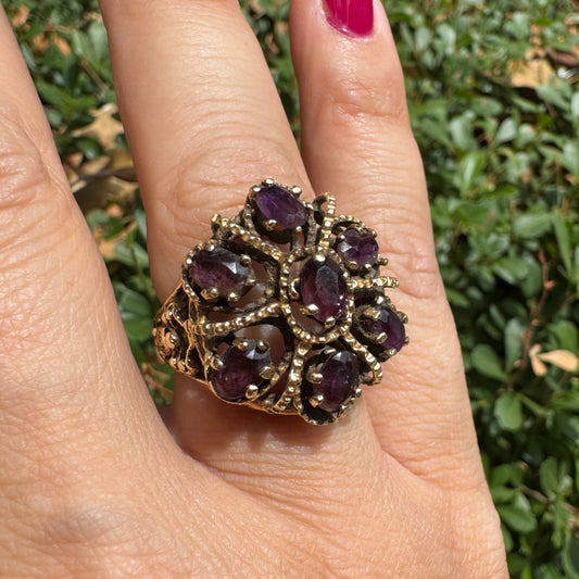 14K gold cocktail ring set with a stunning cluster of deep purple Garnet stones in marquise cuts.