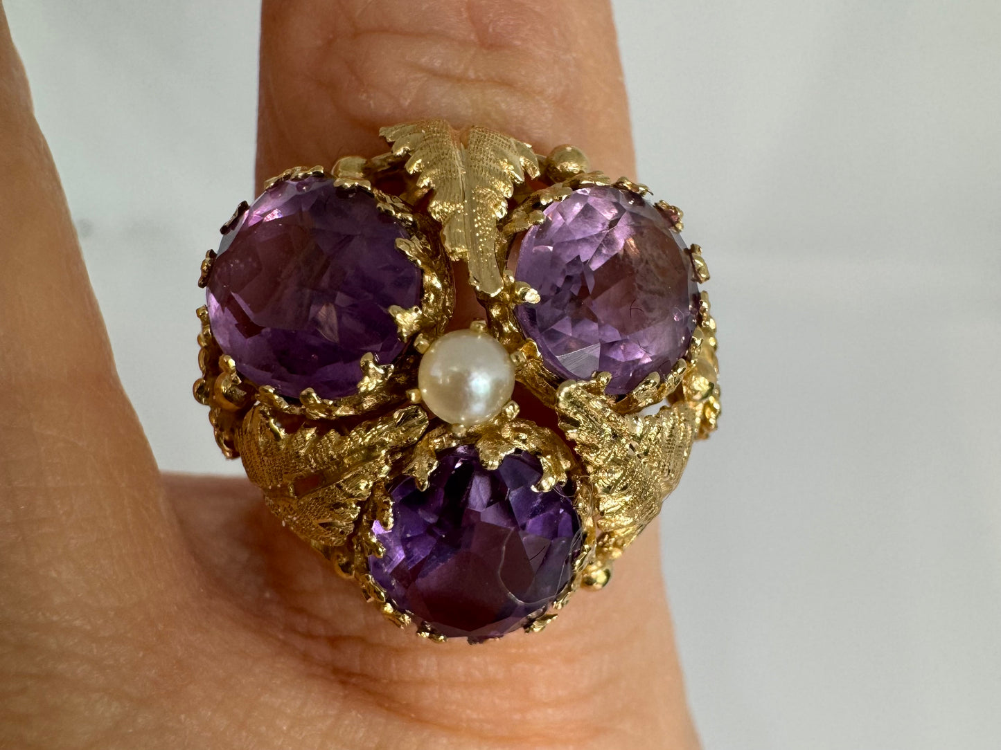 14K gold ring set with four glowing Amethyst stones encircling a delicate central Pearl.