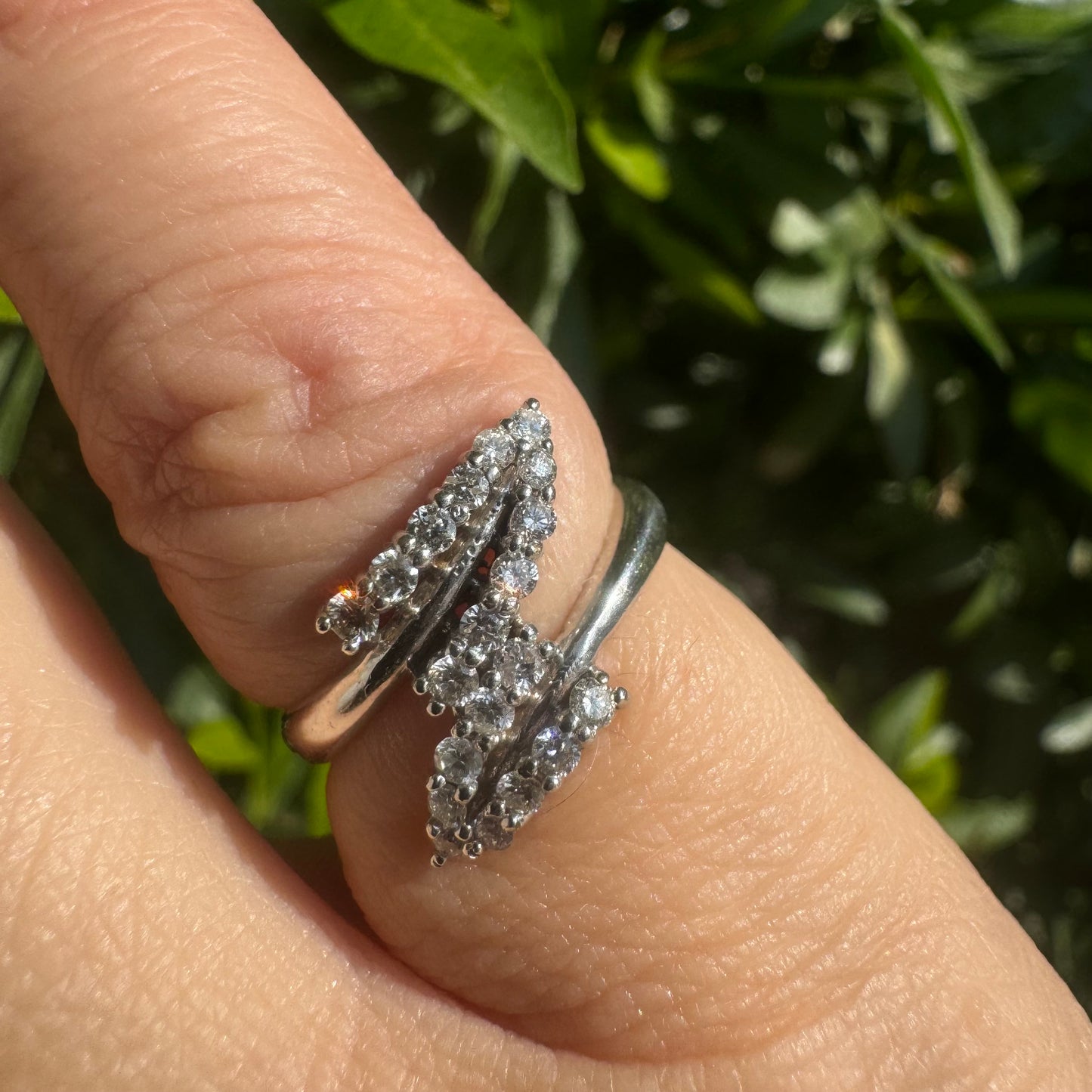 14K gold ring with an open design, featuring two curved rows of sparkling Diamonds that cross over each other elegantly.