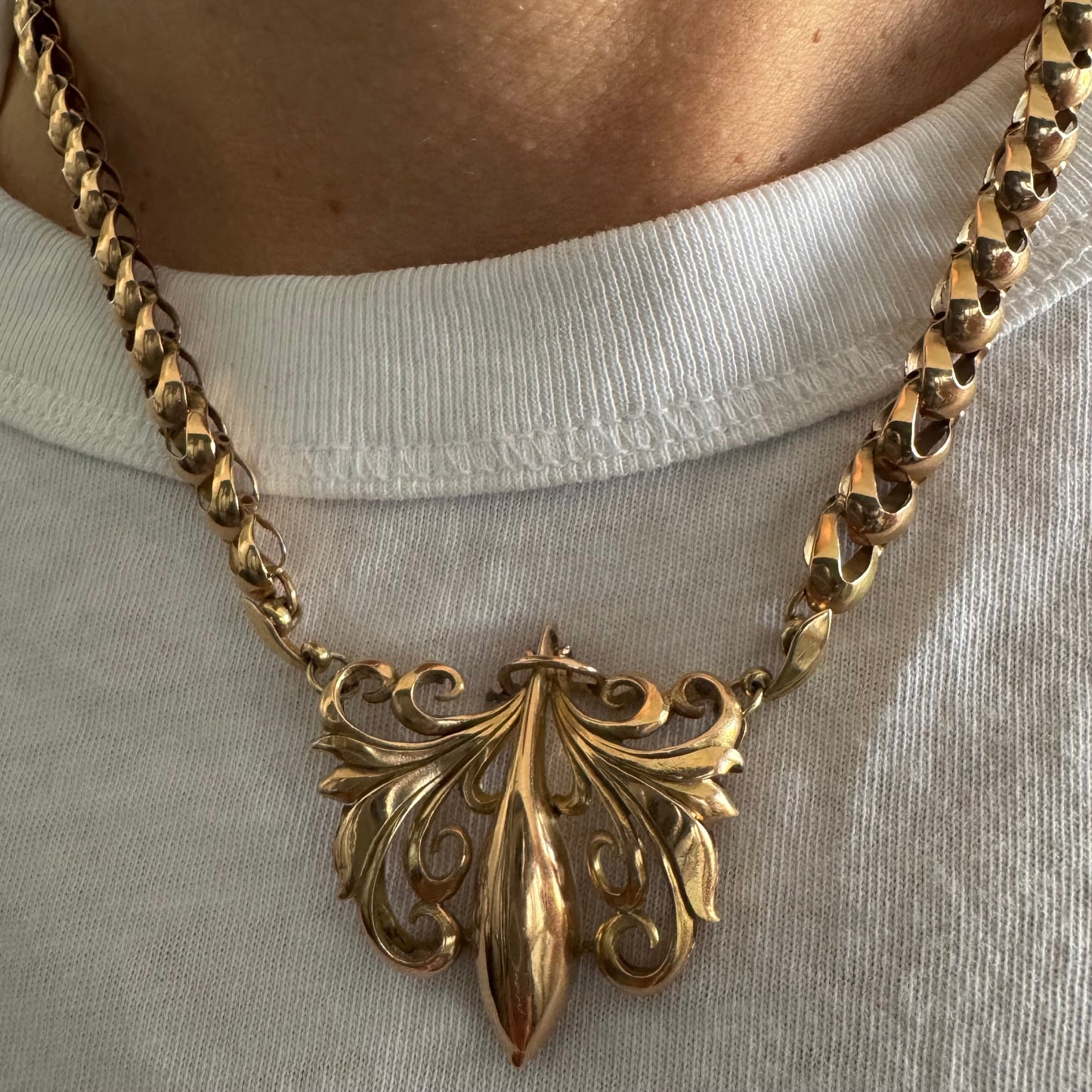 שרשרת זהב 14 קראט בעלת עיטור פלר דה ליס (Fleur-de-lis) אמנותי, המעוצב בקווים מעוגלים של עלי שושן בסגנון אר נובו.