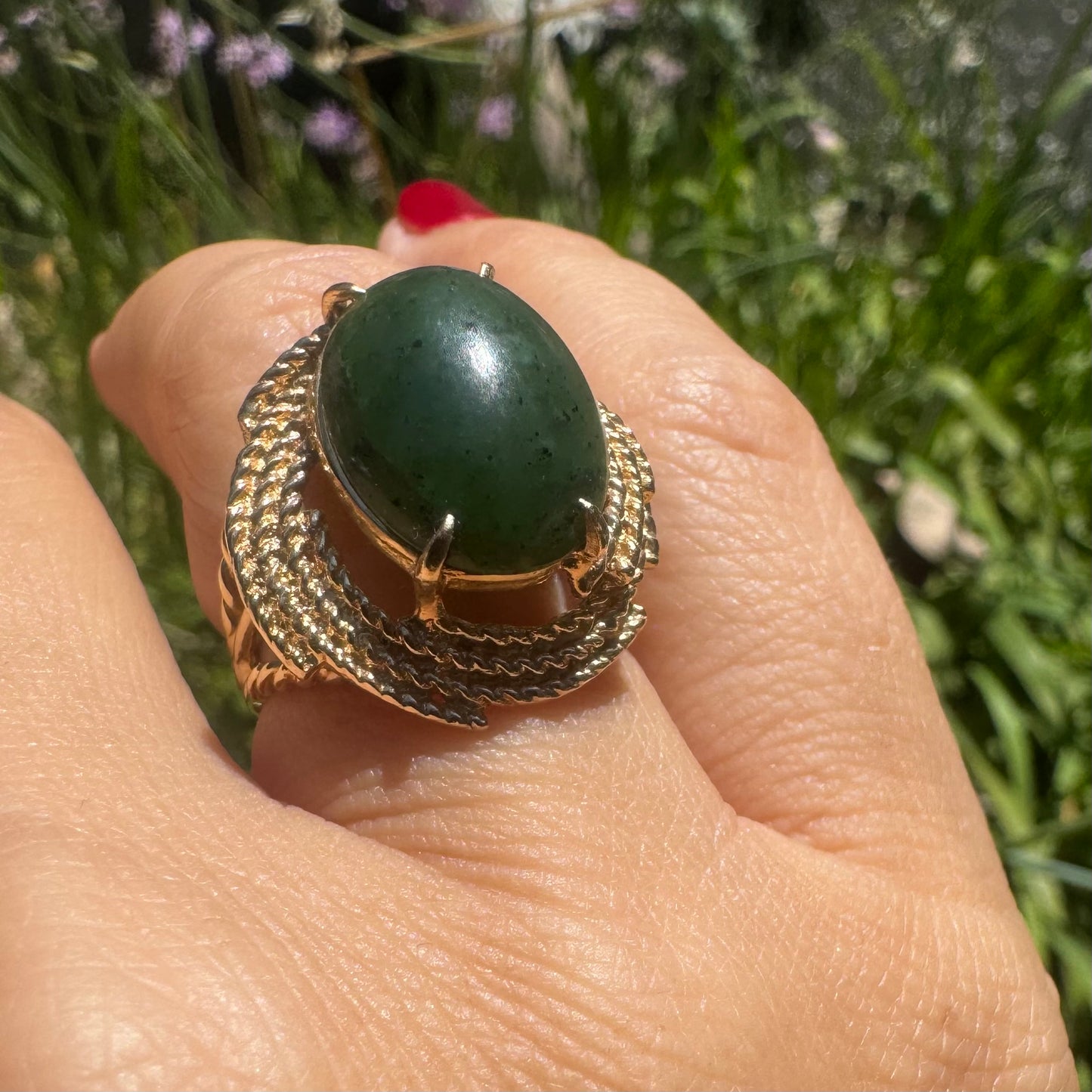 14K gold ring set with a deep green Jade set in a textured gold frame.