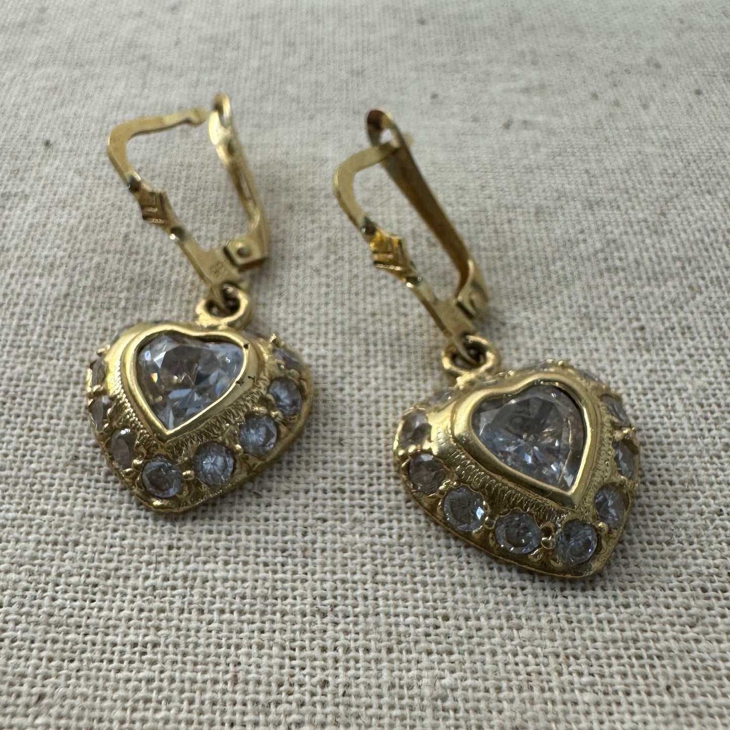 14K gold drop earrings set with a heart-cut central stone & surrounded by a halo of delicate gems.