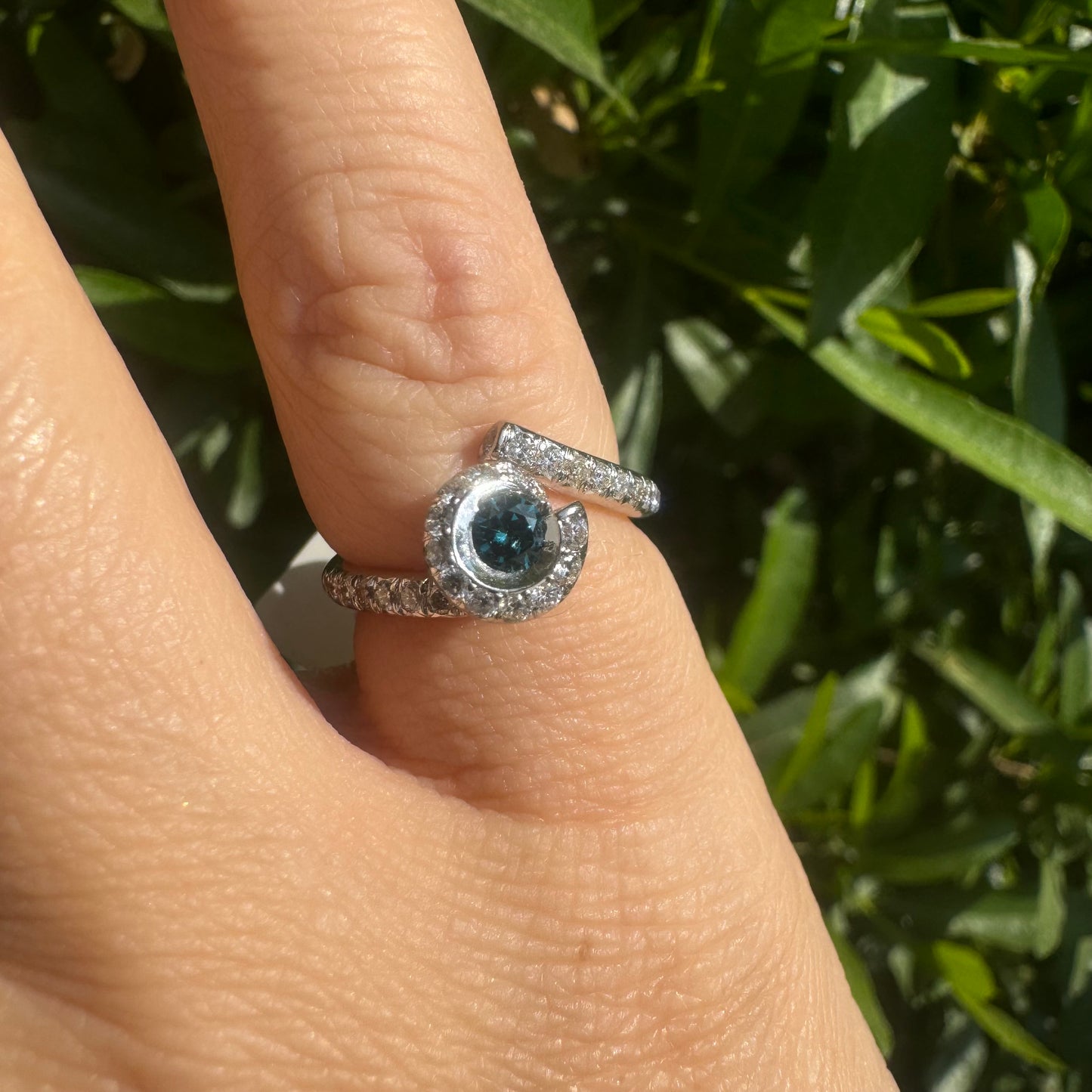 18K gold ring set with a vivid blue Diamond at its heart, embraced by a shimmering halo of white diamonds and a bold open design