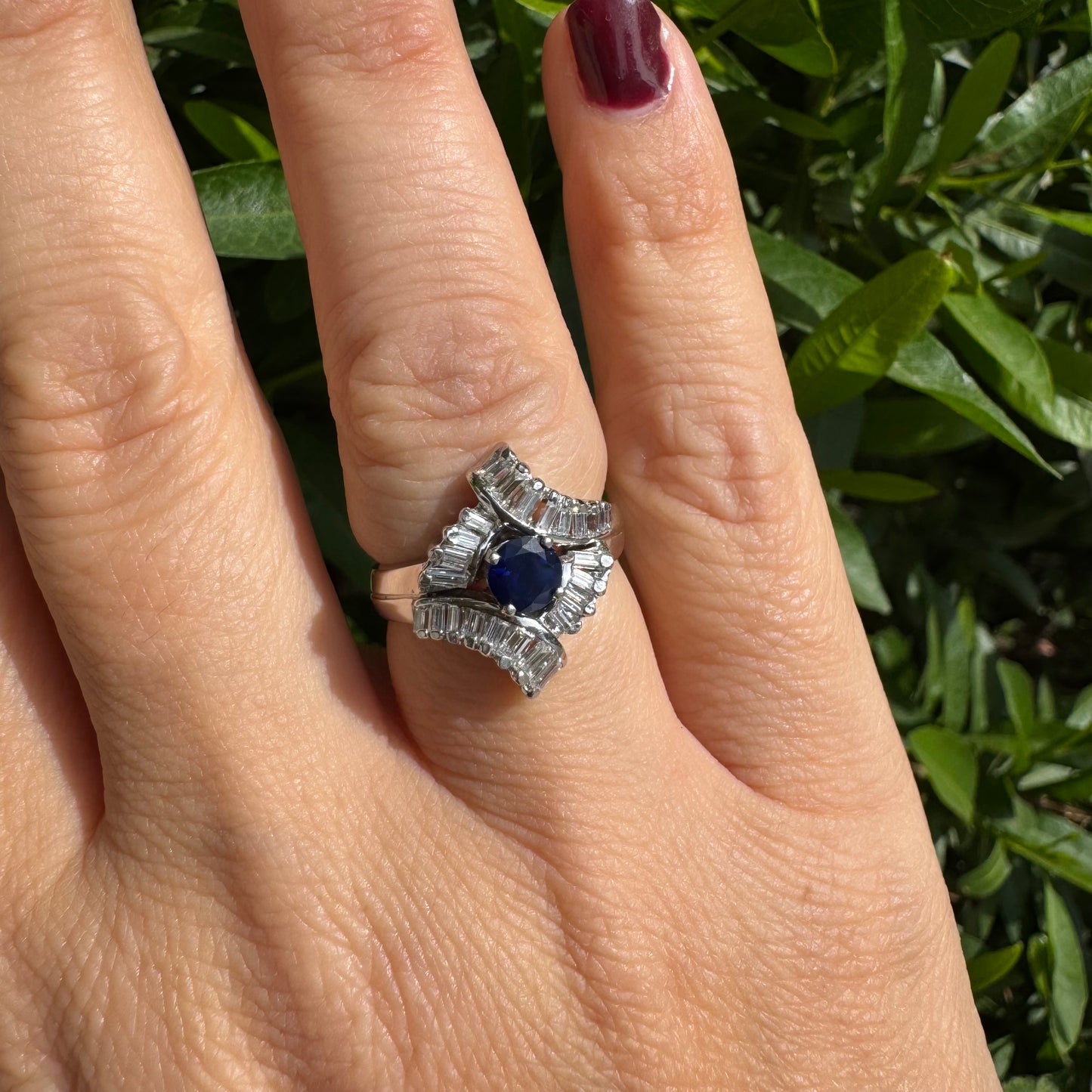 14K gold ring set with a round deep blue sapphire at the center, surrounded by baguette cut Diamonds