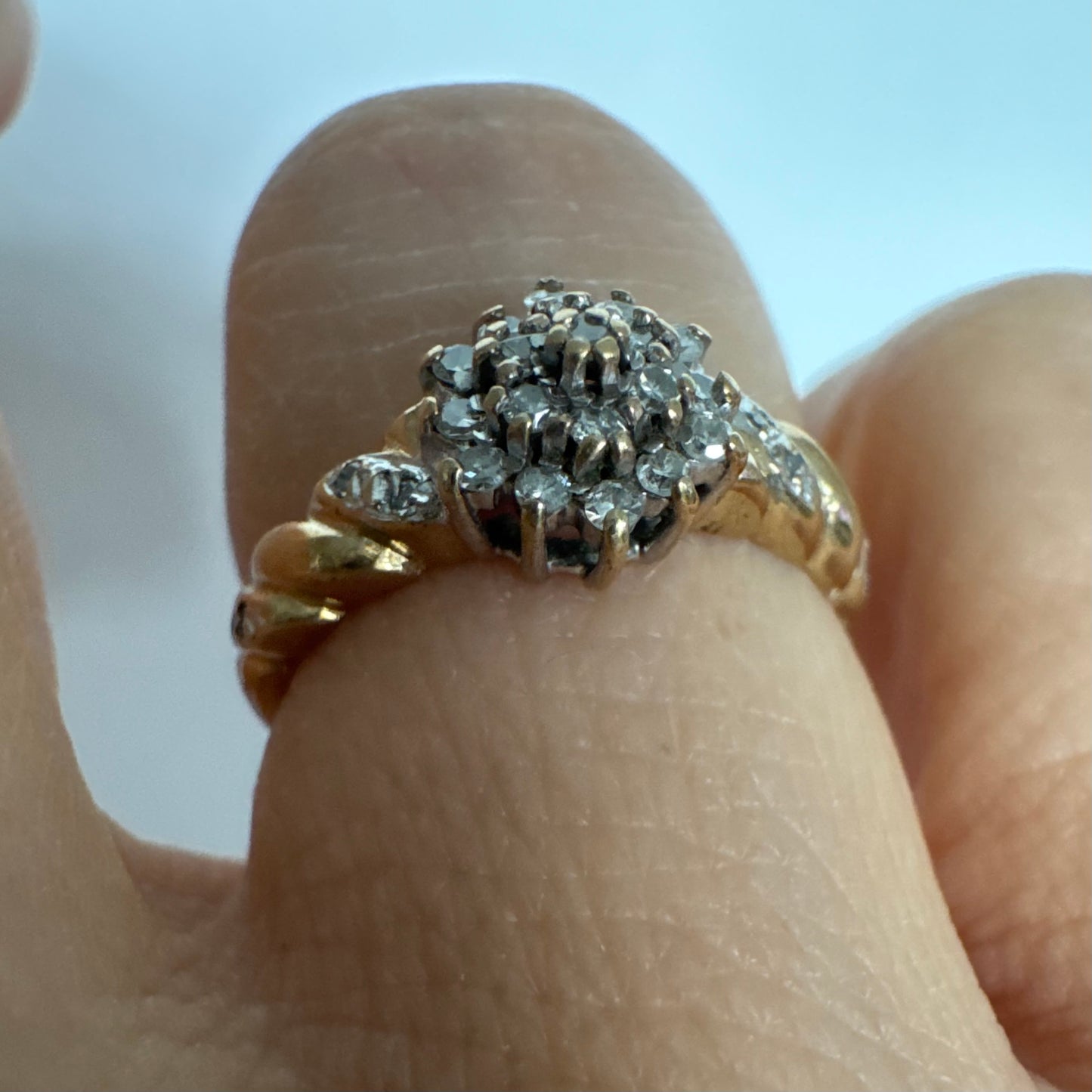 טבעת זהב צהוב 9 קראט משובצת יהלומים בעיצוב פרח עדין.