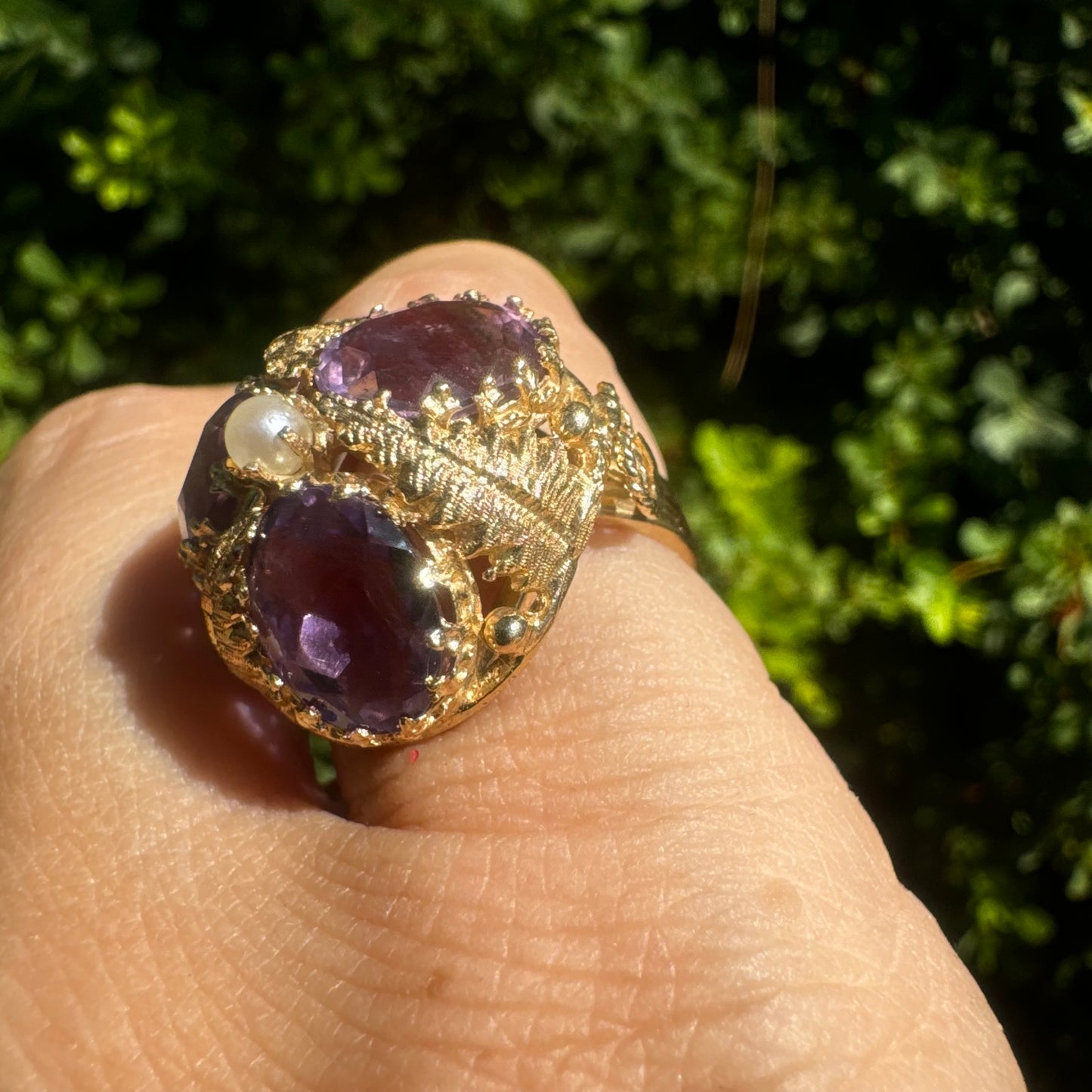 14K gold ring set with four glowing Amethyst stones encircling a delicate central Pearl.