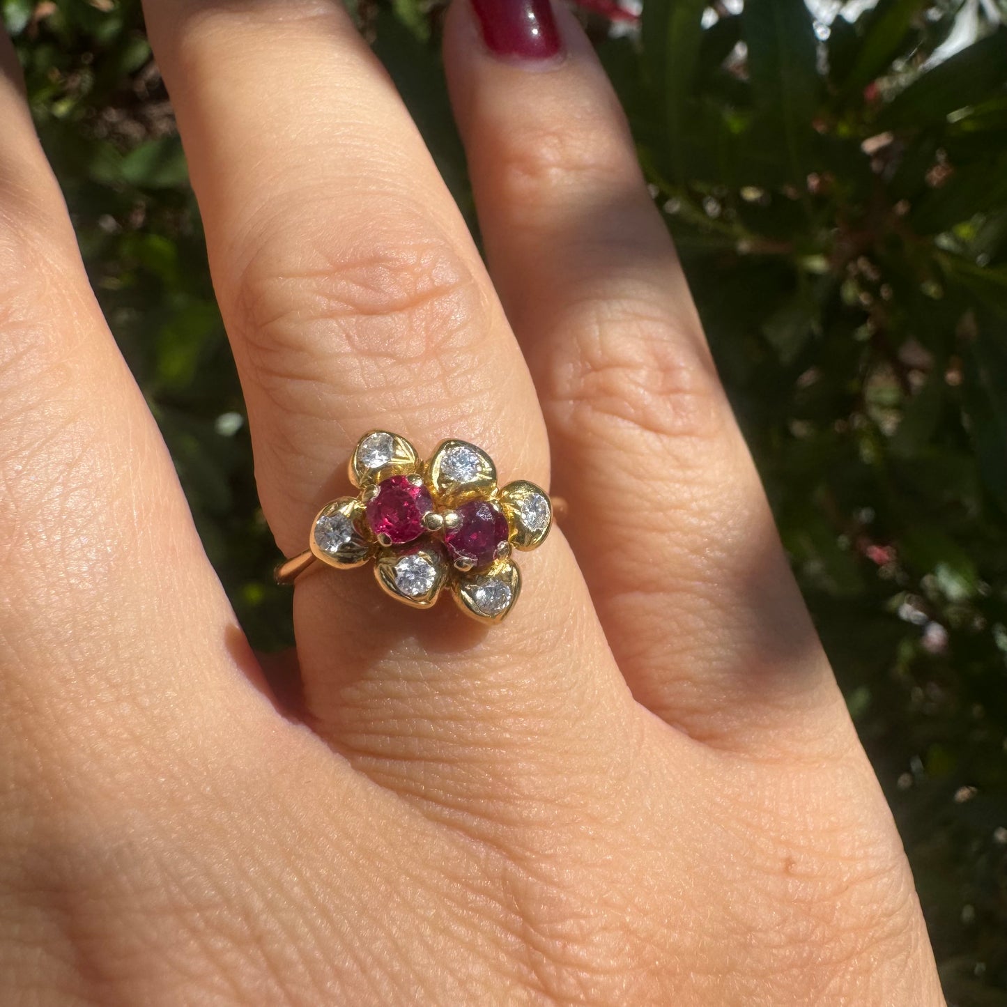 18K gold ring designed like a flower, set with two deep red Rubies and sparkling Diamonds