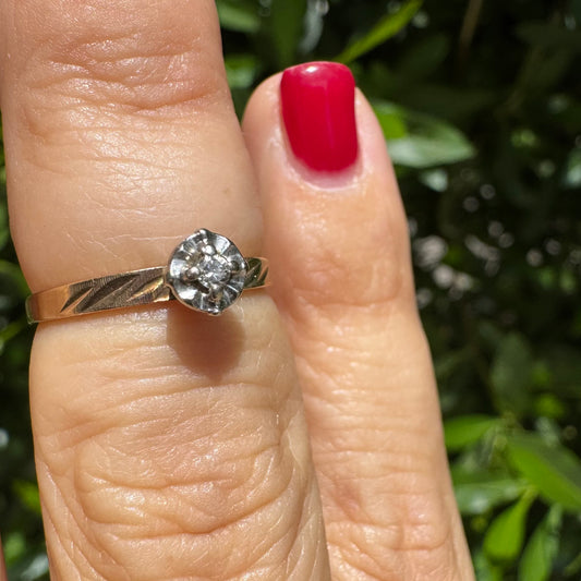 14K gold ring with a delicate floral-style setting, set with a small central Diamond.