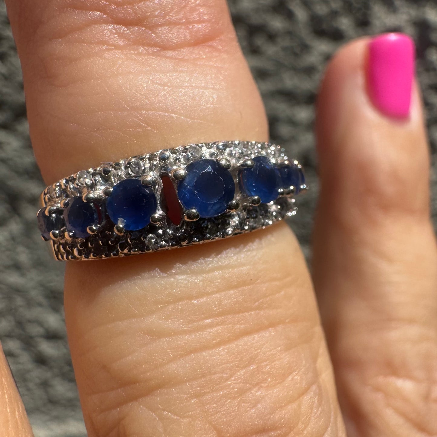18K gold ring set with deep blue sapphires in a classic round cut, framed by two shimmering rows of brilliant Diamonds.