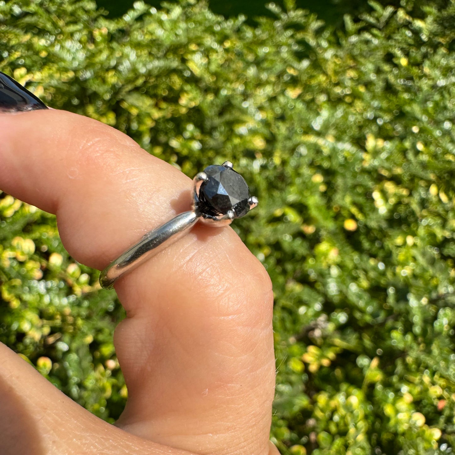 טבעת סוליטר זהב לבן 10 קראט אלגנטית ובעלת נוכחות, משובצת ביהלום שחור בחיתוך עגול במסגרת קלאסית בעלת ארבע שיניים מזהב לבן.