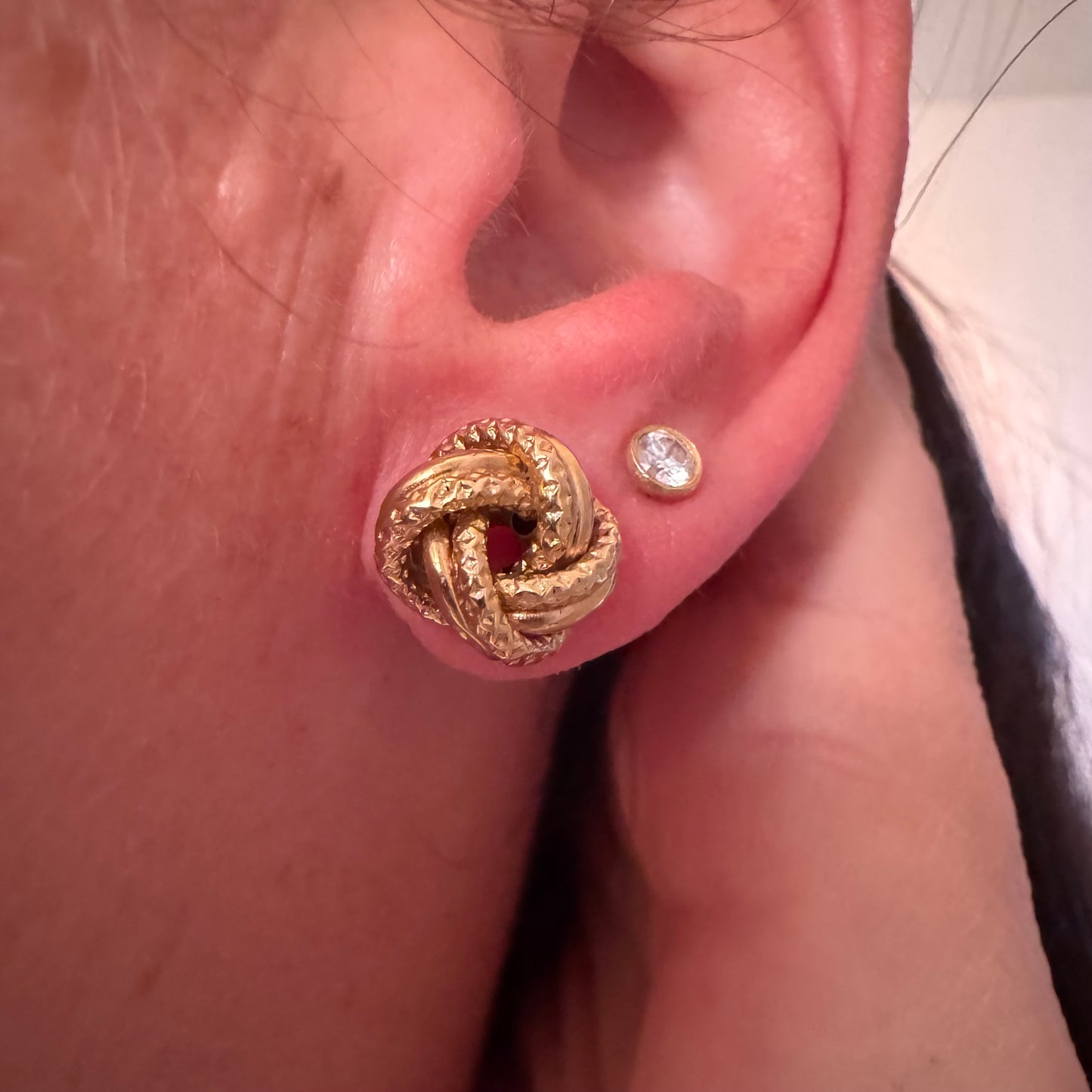 עגילי זהב צהוב 18 קראט בעיצוב קשר פיסולי, עם טקסטורה עשירה המדגישה את עומק וצורת הזהב.