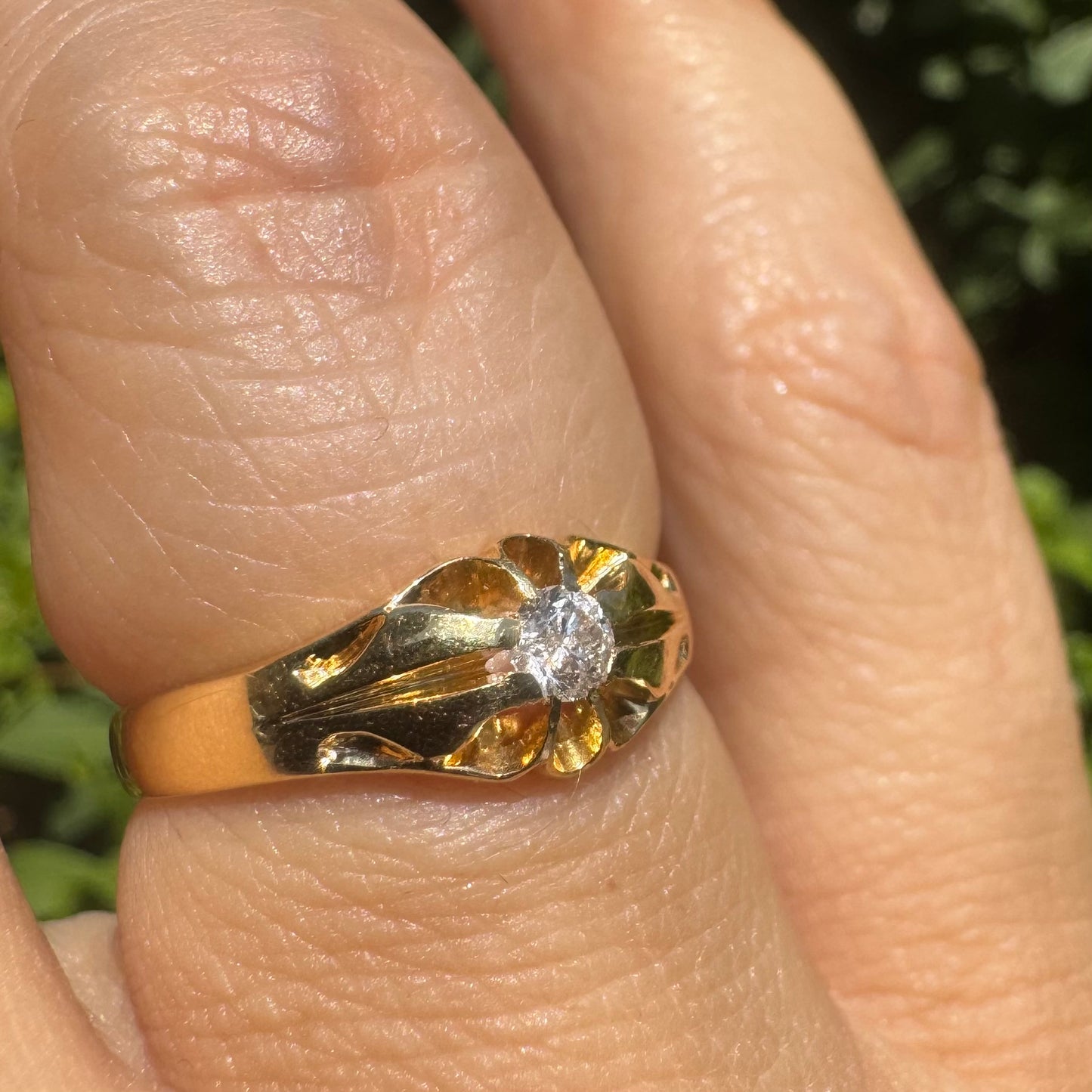 18K gold ring set with a small sparkling diamond at the center.