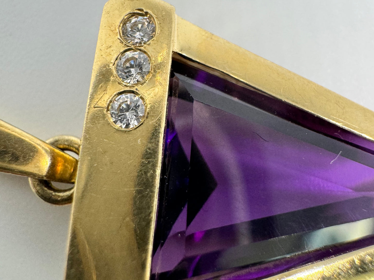 14K yellow gold pendant set with a triangular-cut amethyst and three accent diamonds