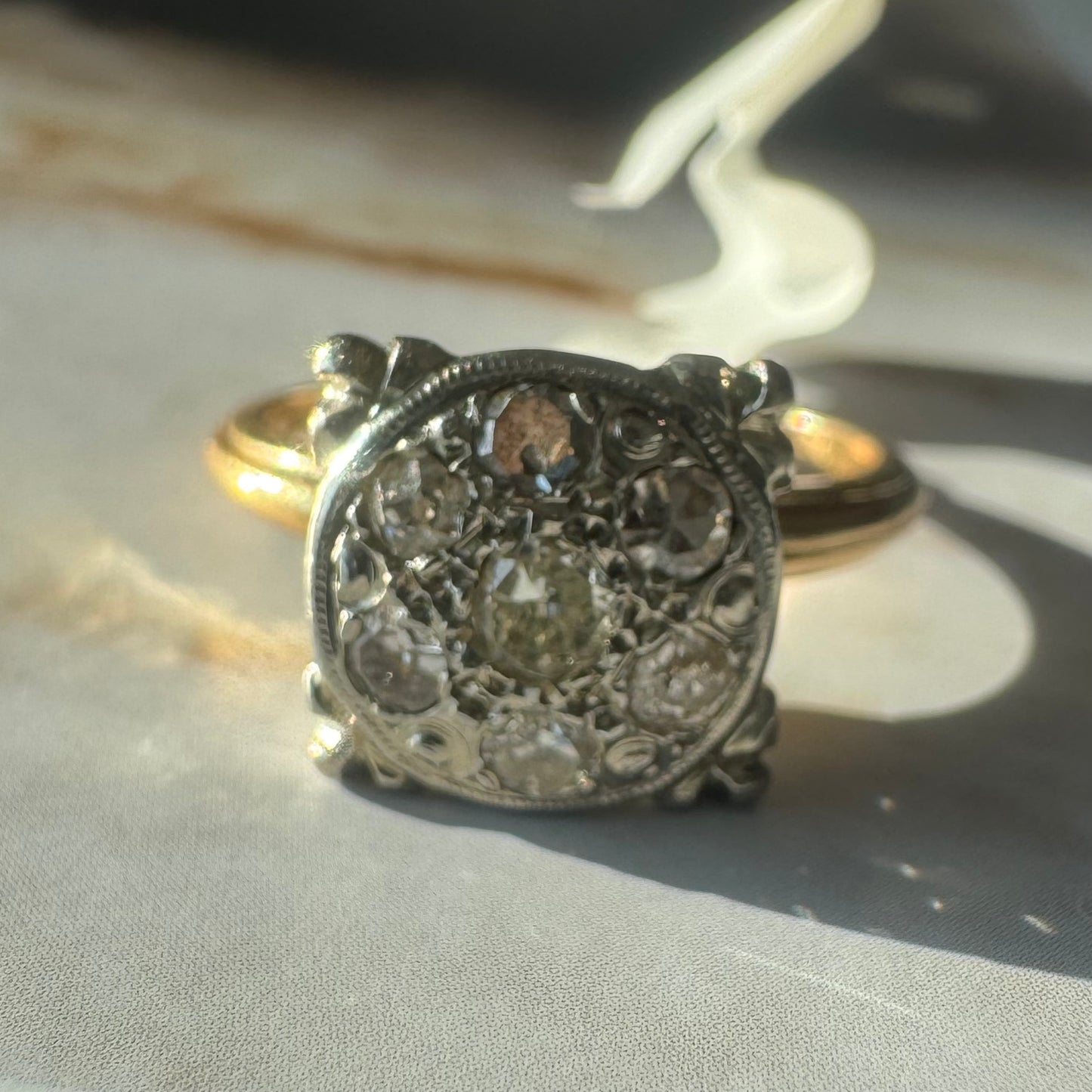 14K gold ring set with an old-cut Diamond at its center, encircled by a pavé cluster of smaller Diamonds in a round, ornate setting.