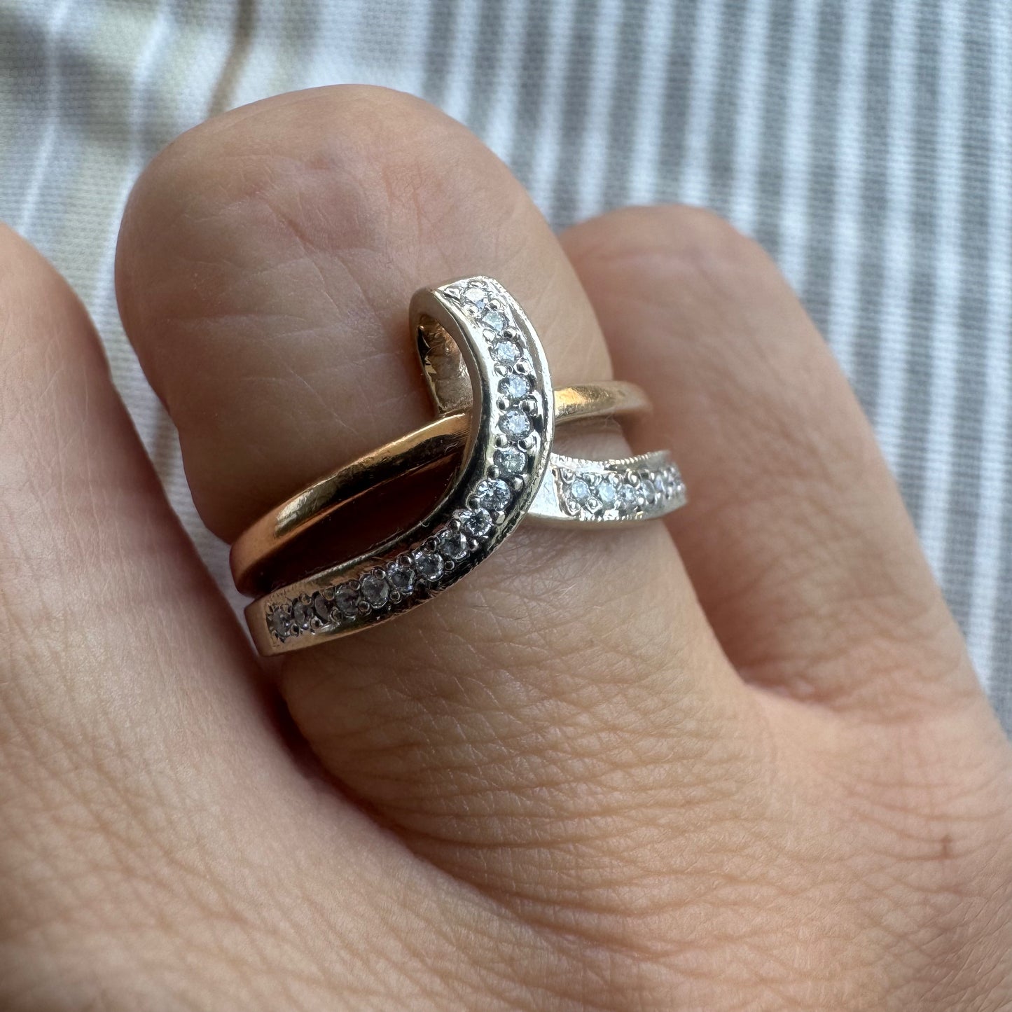 18K two-tone gold (rose & white) crossover ring featuring a row of sparkling Diamonds along each band, creating an elegant and modern design.