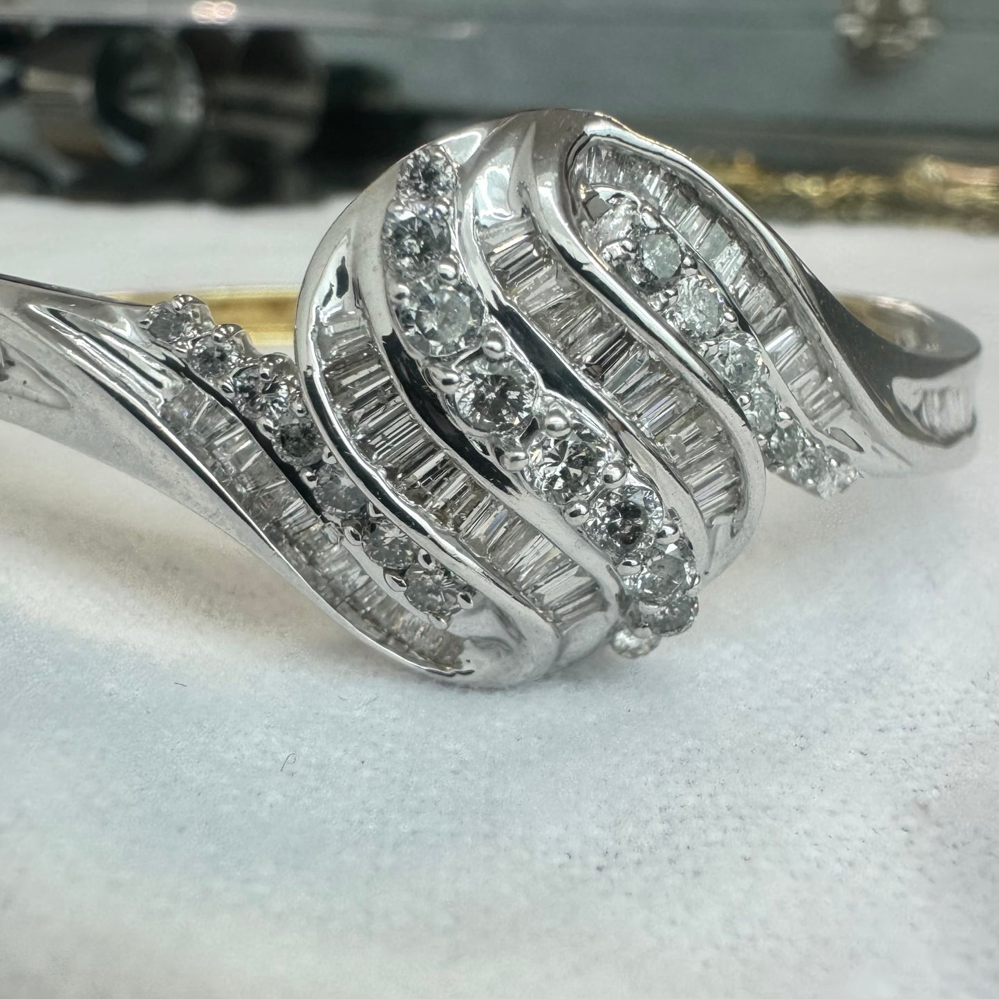 צמיד מרהיב מזהב לבן 14 קראט, בעיצוב גלים דינמי המשובץ בשיבוץ מרוכב של יהלומים עגולים ובחיתוך באגט.