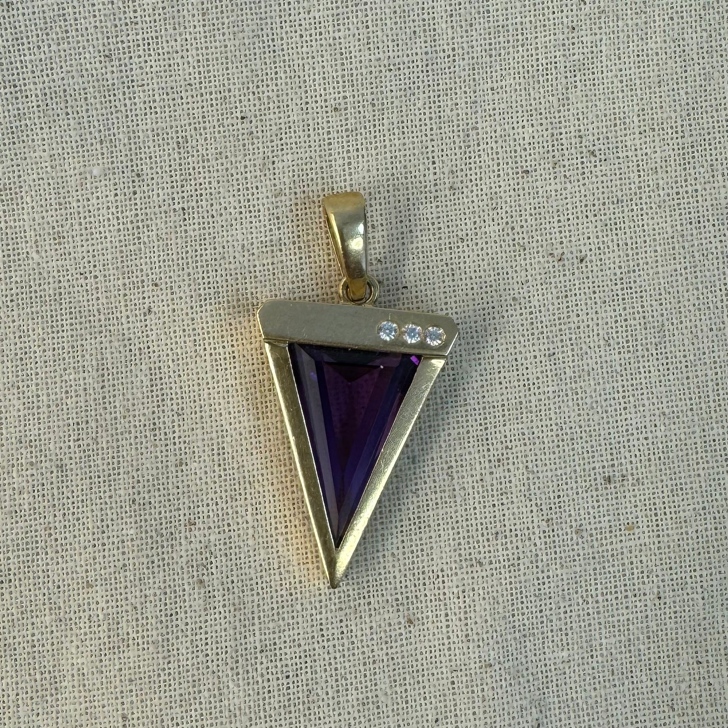 14K yellow gold pendant set with a triangular-cut amethyst and three accent diamonds