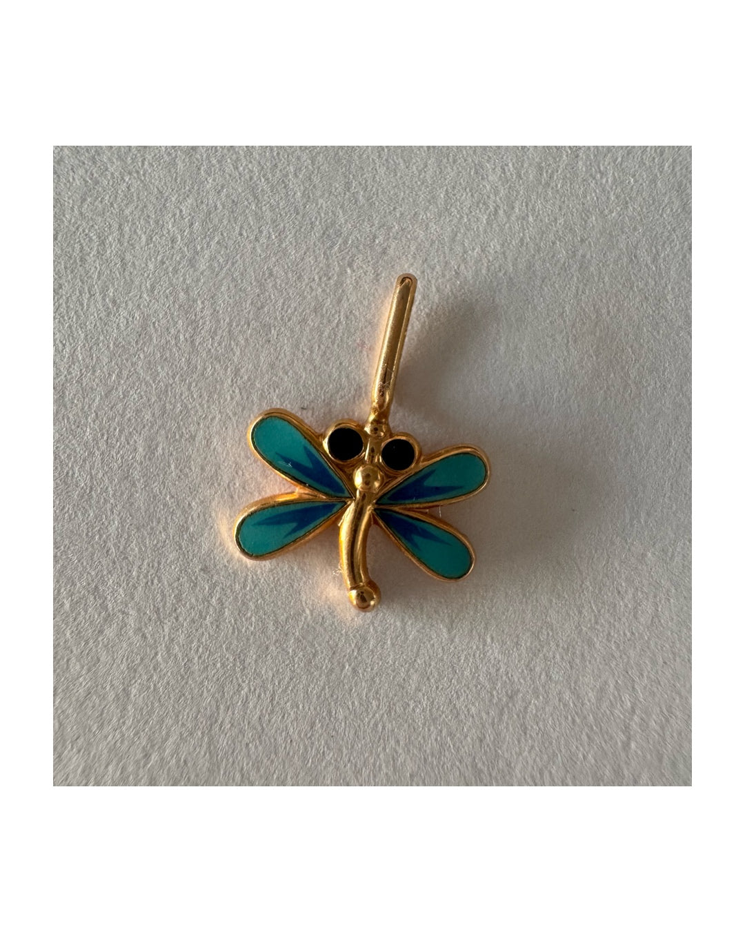 תליון זהב 14 קראט בעיצוב שפירית, עם עבודת אמייל כחולה ופרטים עדינים שמעניקים לו מראה צבעוני ואלגנטי.