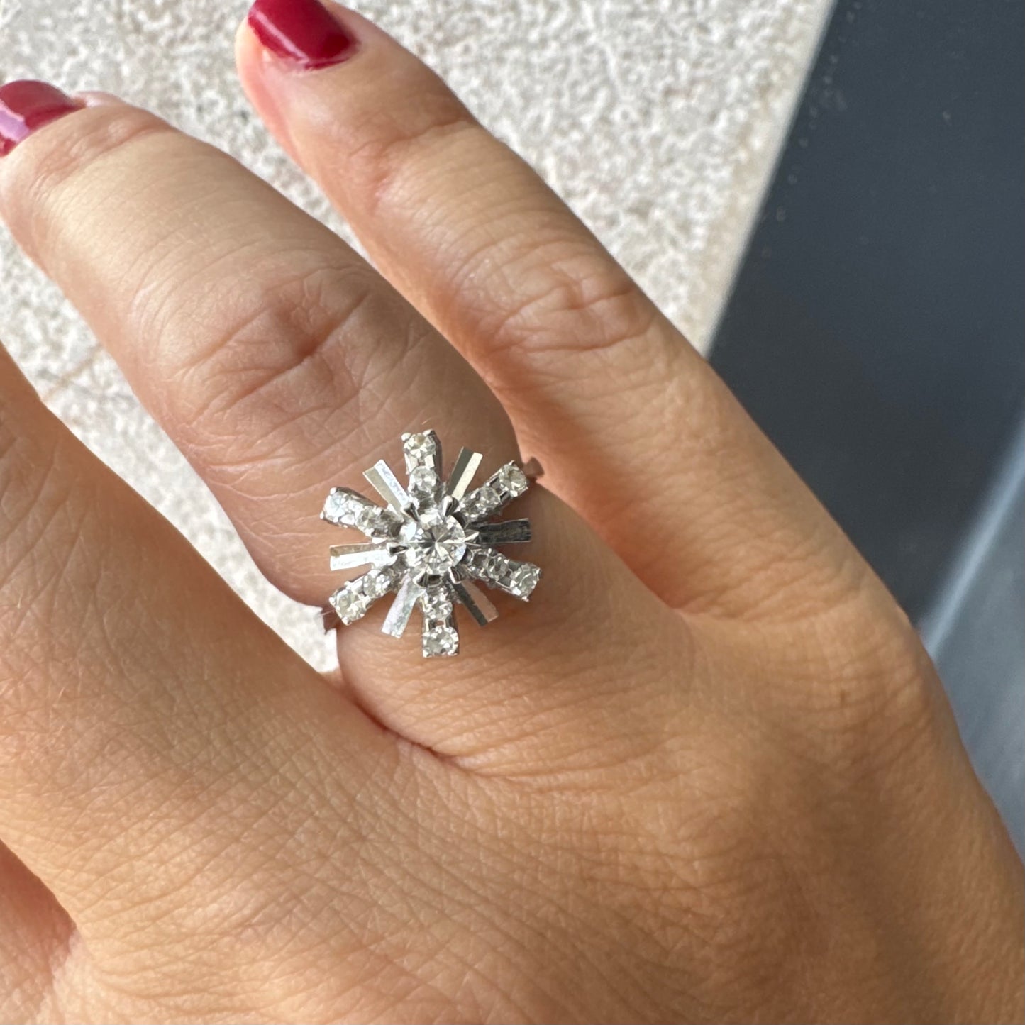 טבעת זהב לבן 18 קראט בעיצוב קרני שמש מרהיב, משובצת יהלומים הלוכדים את האור מכל כיוון. 