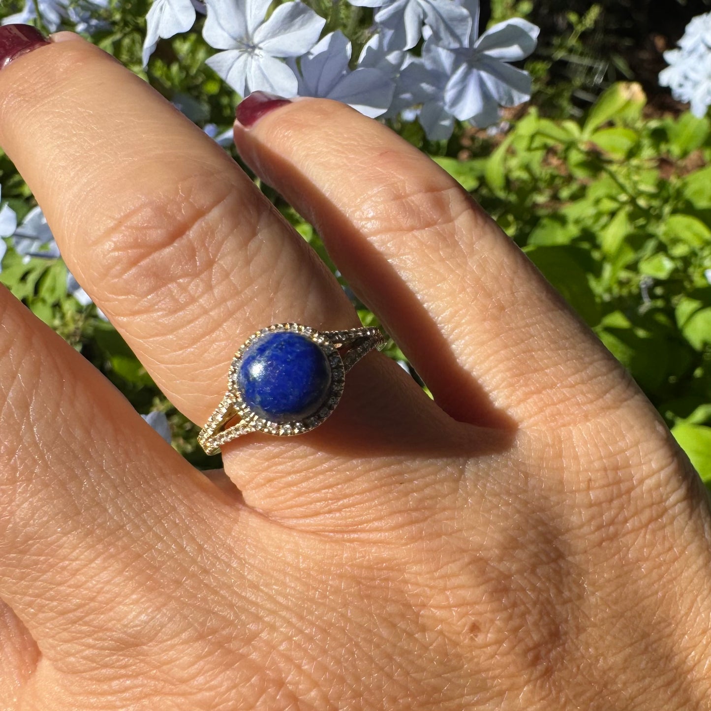 14K gold ring set with a round Lapis Lazuli gemstone, surrounded by a delicate halo of sparkling Diamonds.
