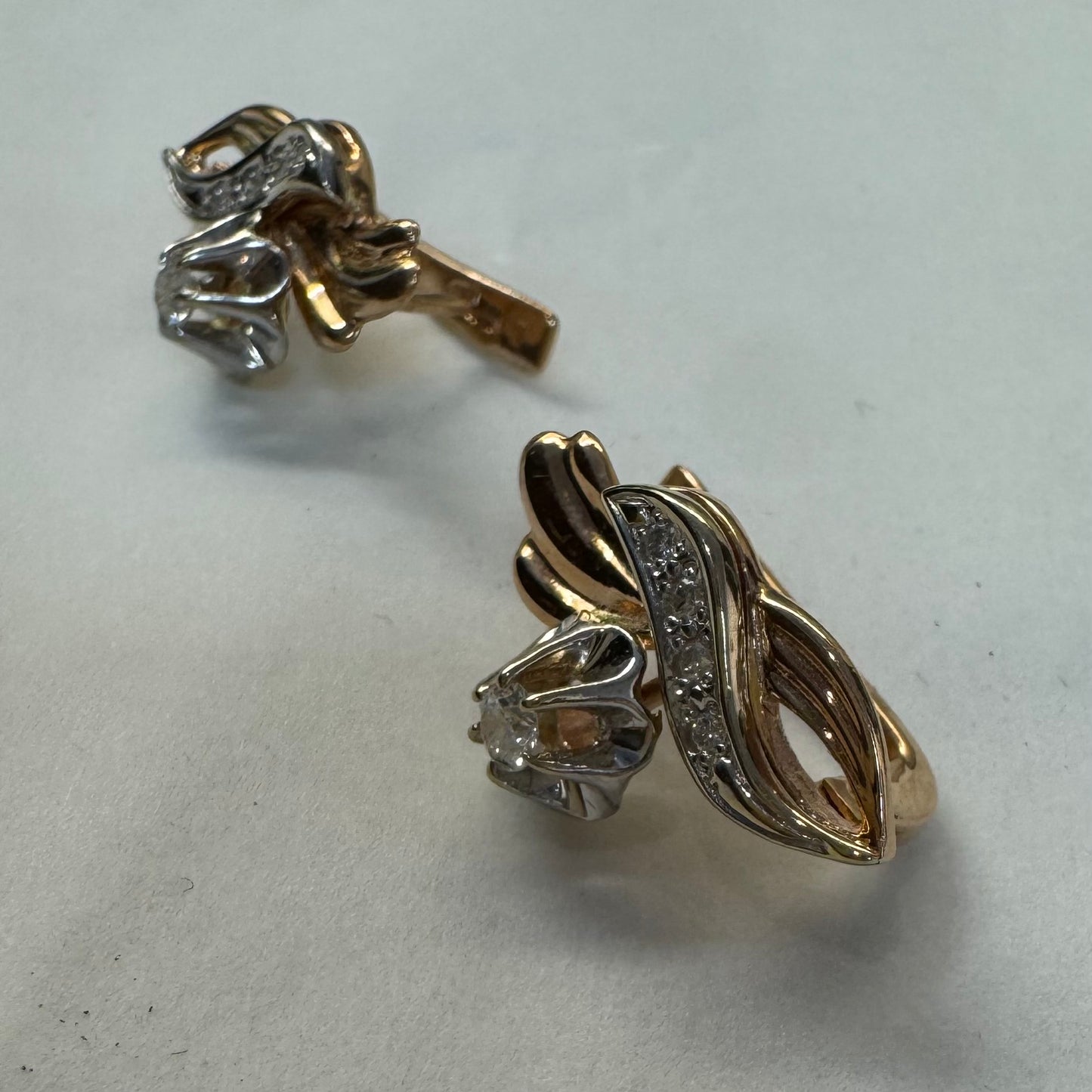 עגילי זהב 14 קראט בעיצוב מתעגל ואלגנטי המשובצים יהלומים נוצצים .