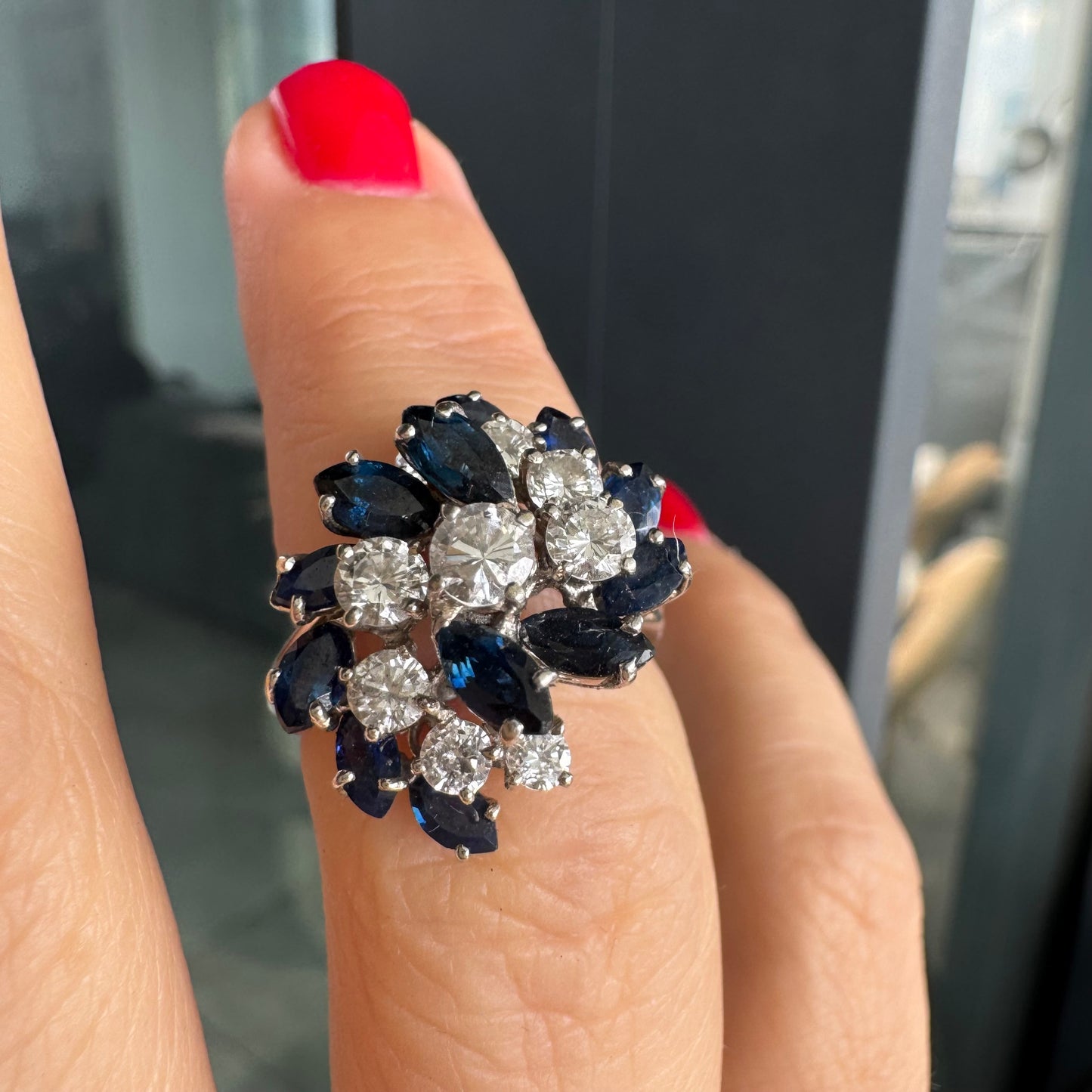 טבעת זהב לבן 18 קראט, משובצת אבני ספיר כחולות בחיתוך מרקיזה ויהלומים עגולים, בעיצוב אשכול קלאסי ואלגנטי.