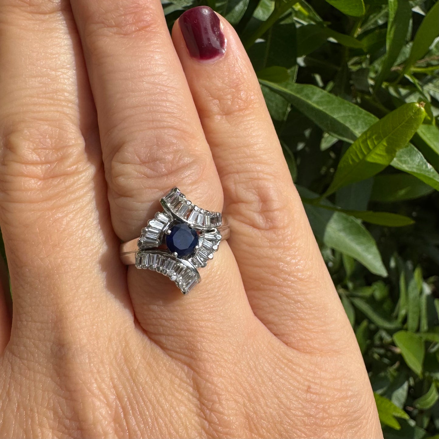 14K gold ring set with a round deep blue sapphire at the center, surrounded by baguette cut Diamonds