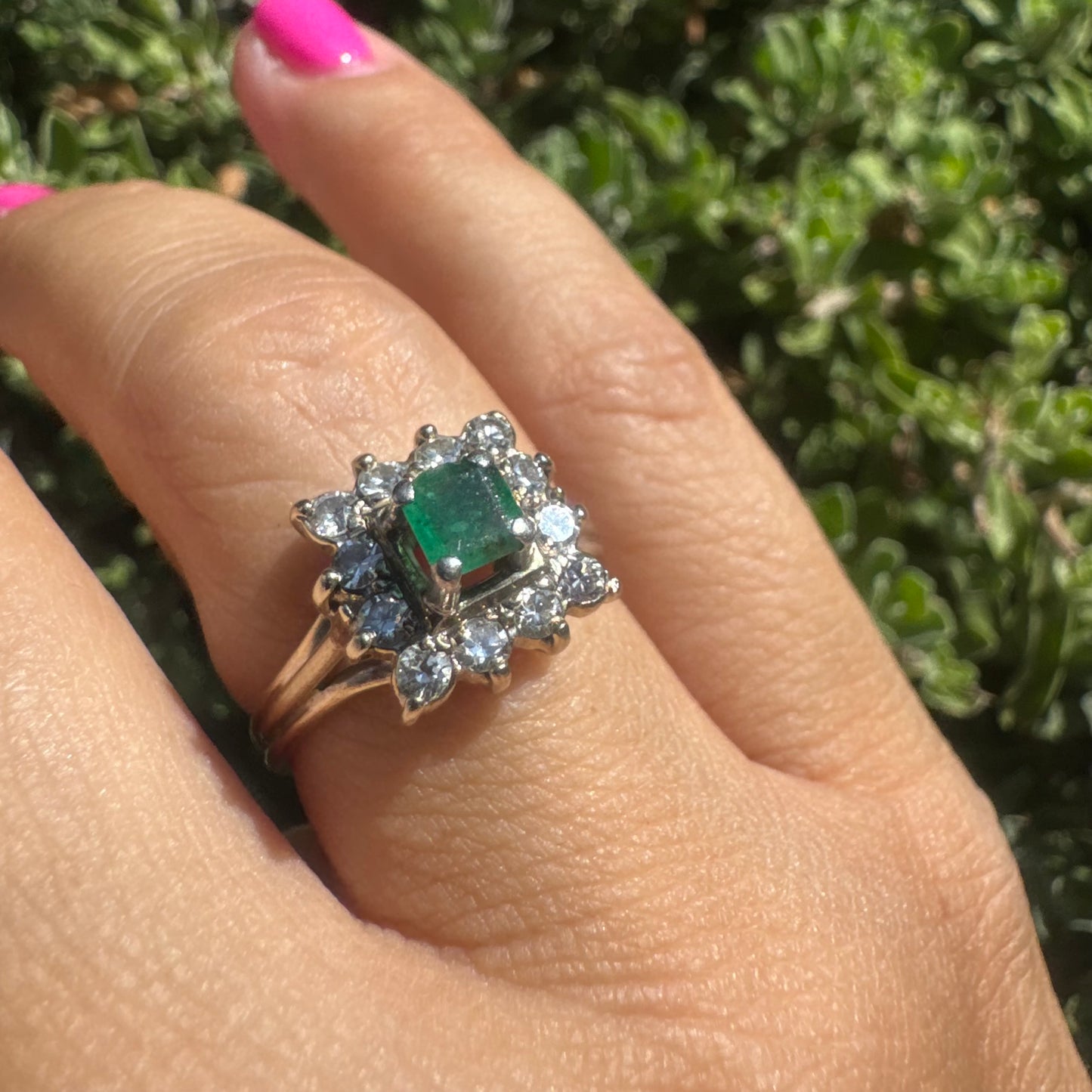 18K gold ring set with a vibrant square-cut Emerald surrounded by a sparkling halo of Diamonds.
