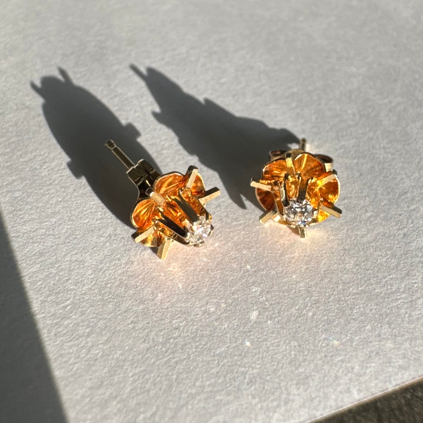 עגיל צמוד זהב צהוב 14 קראט בעיצוב פרח עדין, עם יהלום לבן במרכזו.